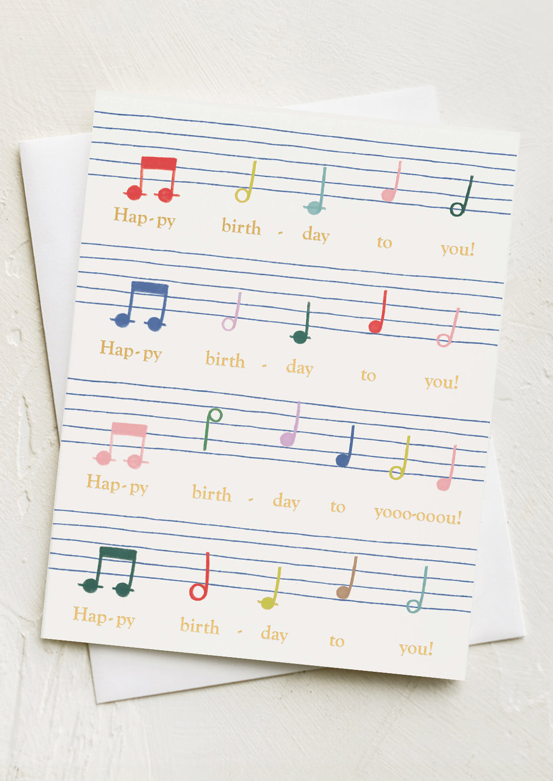 A card with rainbow colored sheet music to the tune of Happy Birthday song.