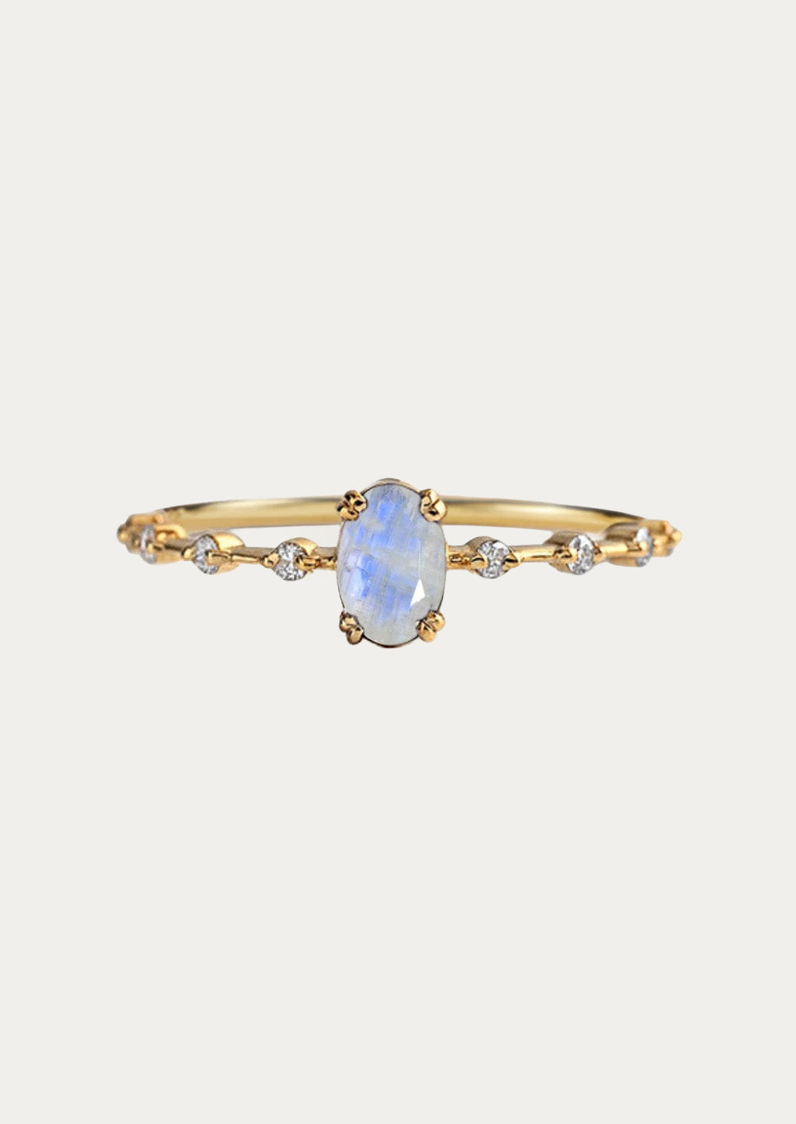 A gold ring with a natural oval moonstone in the center and cubic zirconia along the band.