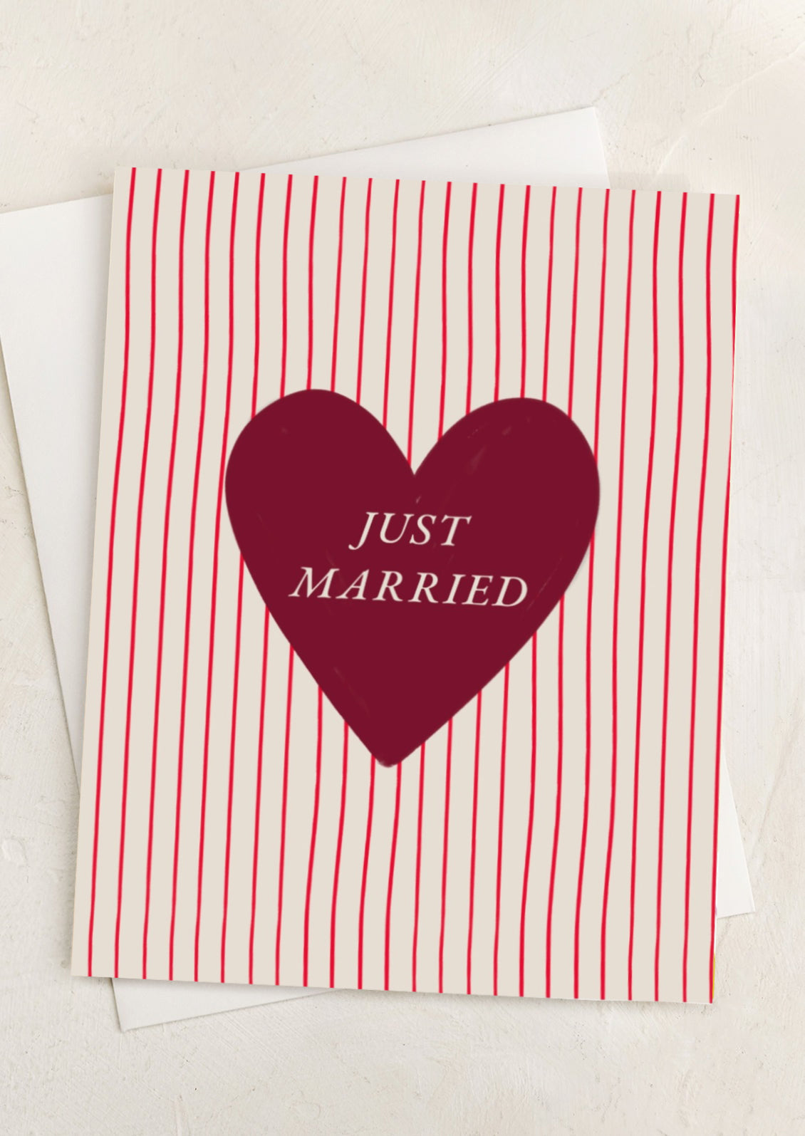 A red striped greeting card with heart at center reading "Just married".