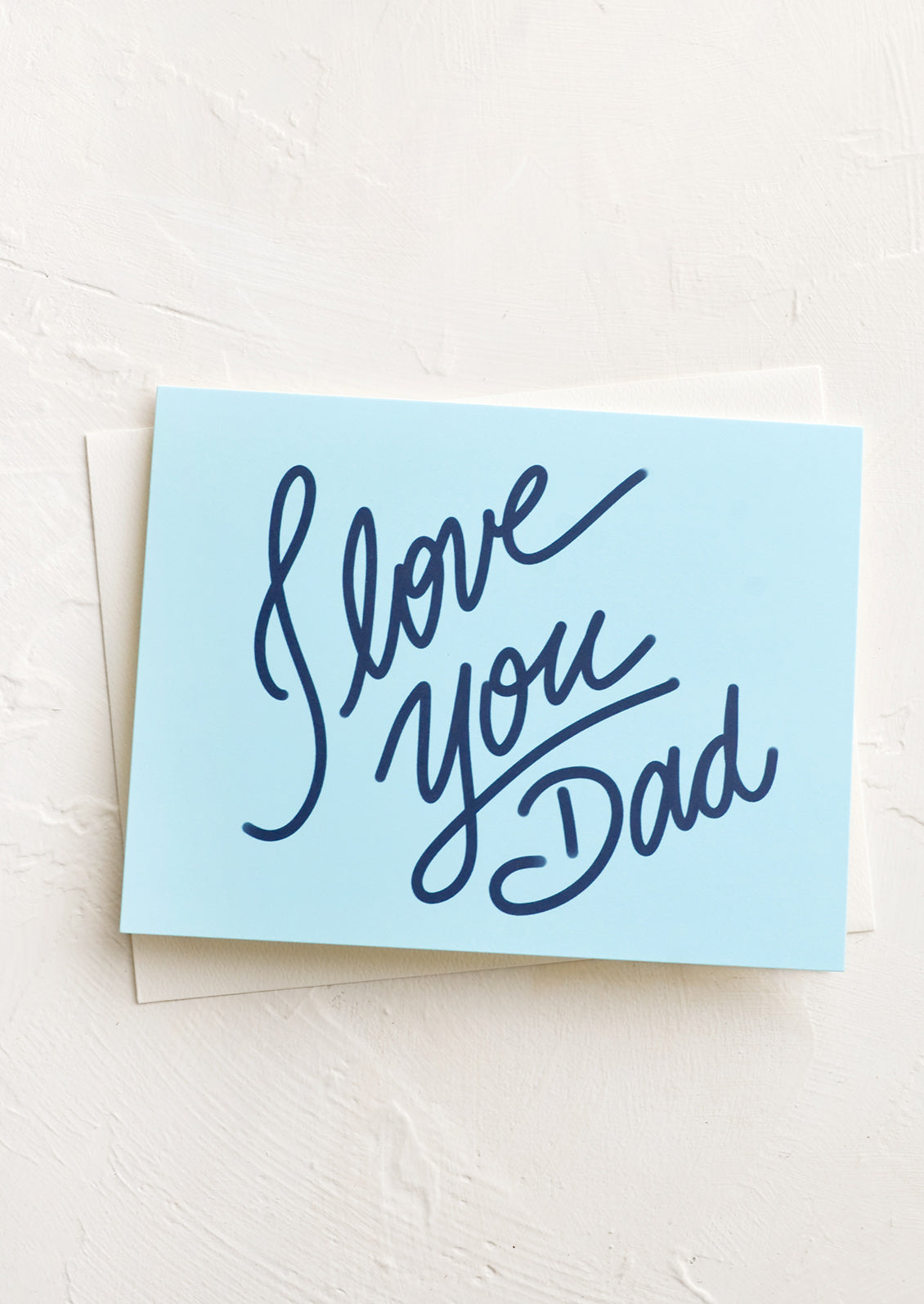 A blue greeting card with cursive lettering.