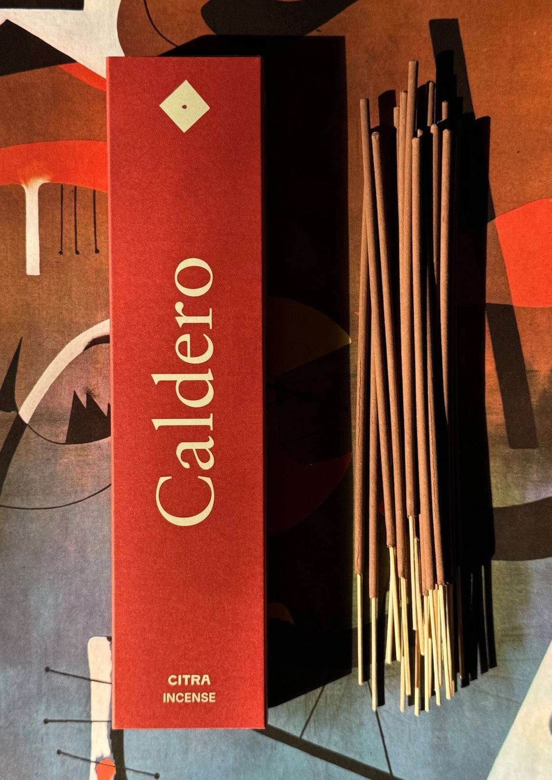 A pack of incense in "Caldero" scent, box is red.