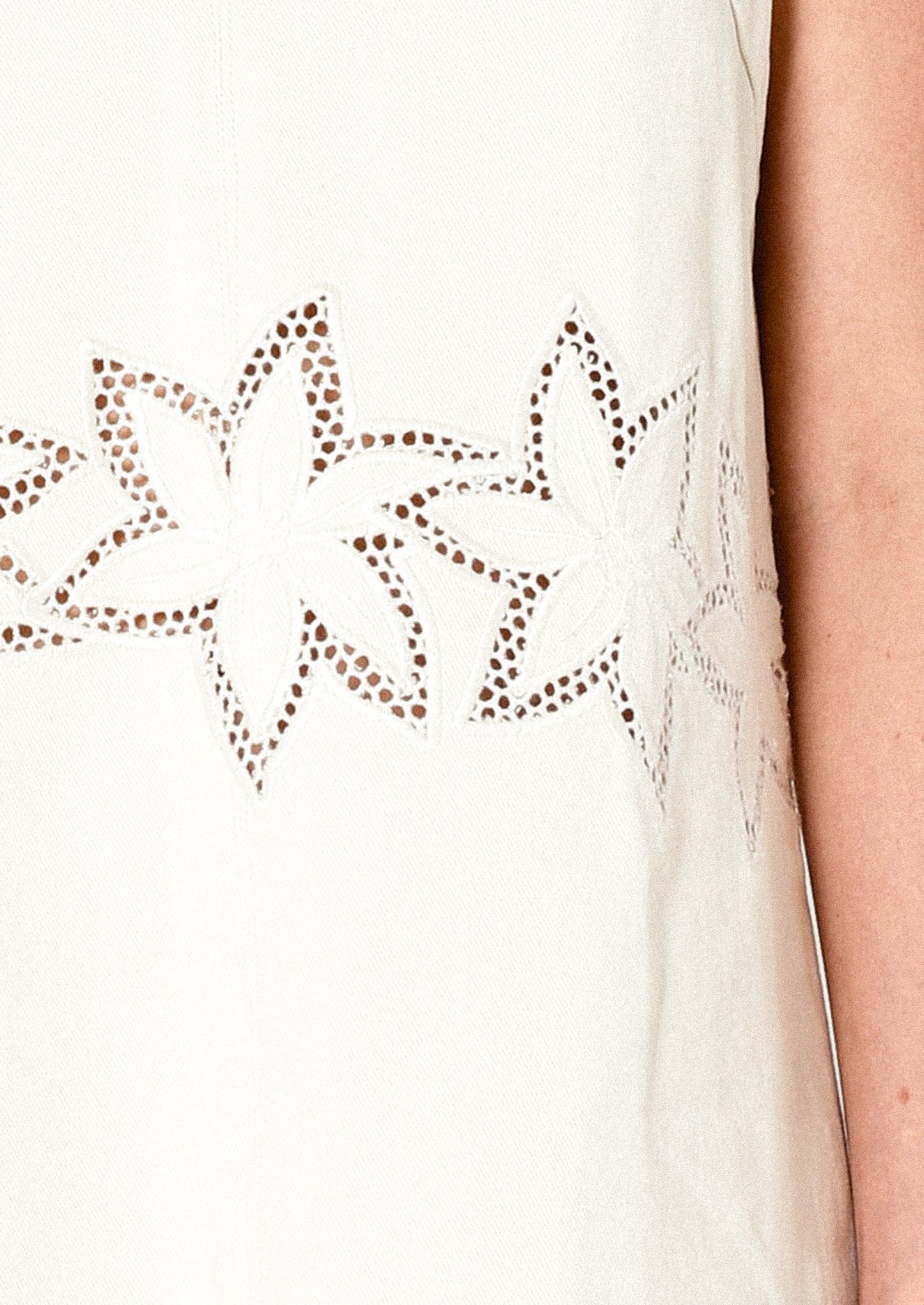 Close-up of a white sleeveless top with star-shaped cutouts.