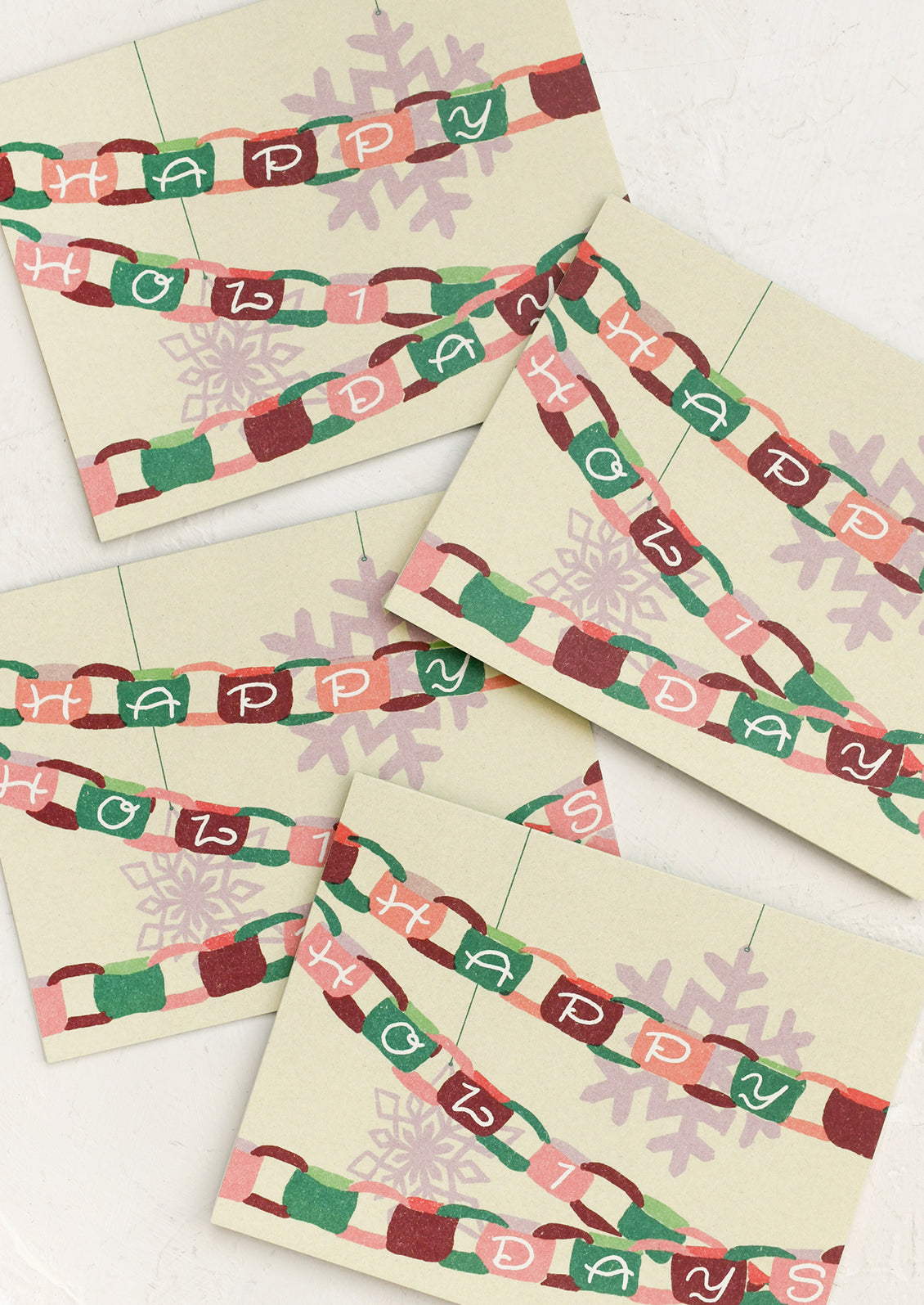 A set of greeting cards with depiction of paper chain garland, text reads "Happy Holidays".