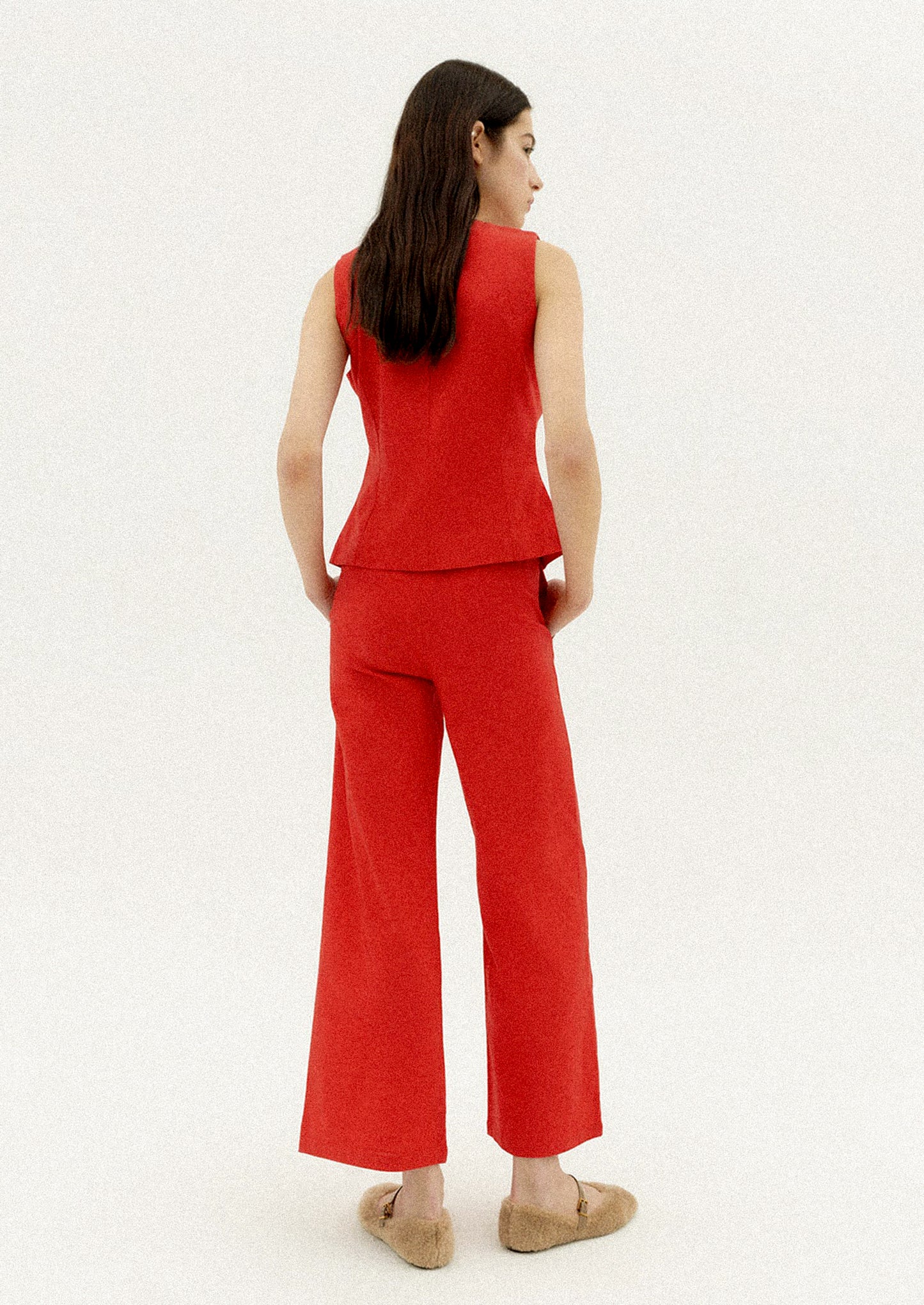 A woman wearing a red sleeveless top with front ties.