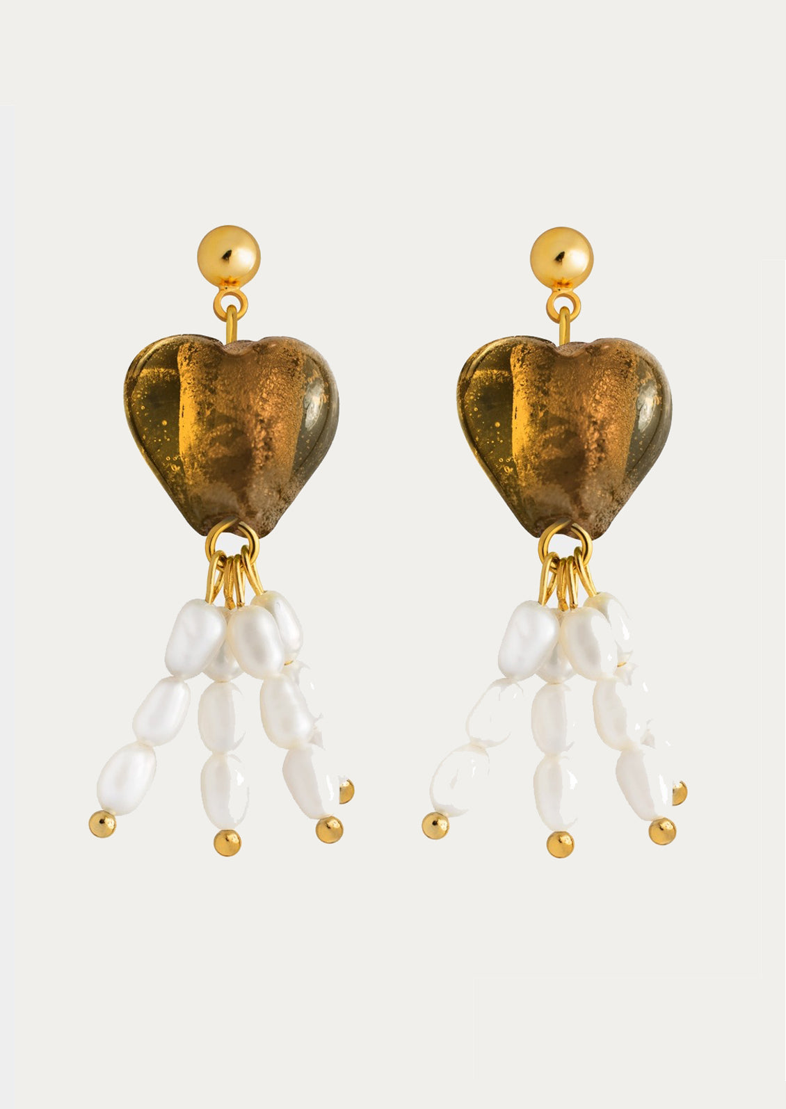 A pair of earrings with post stud, amber colored glass heart and pearl drop charms.