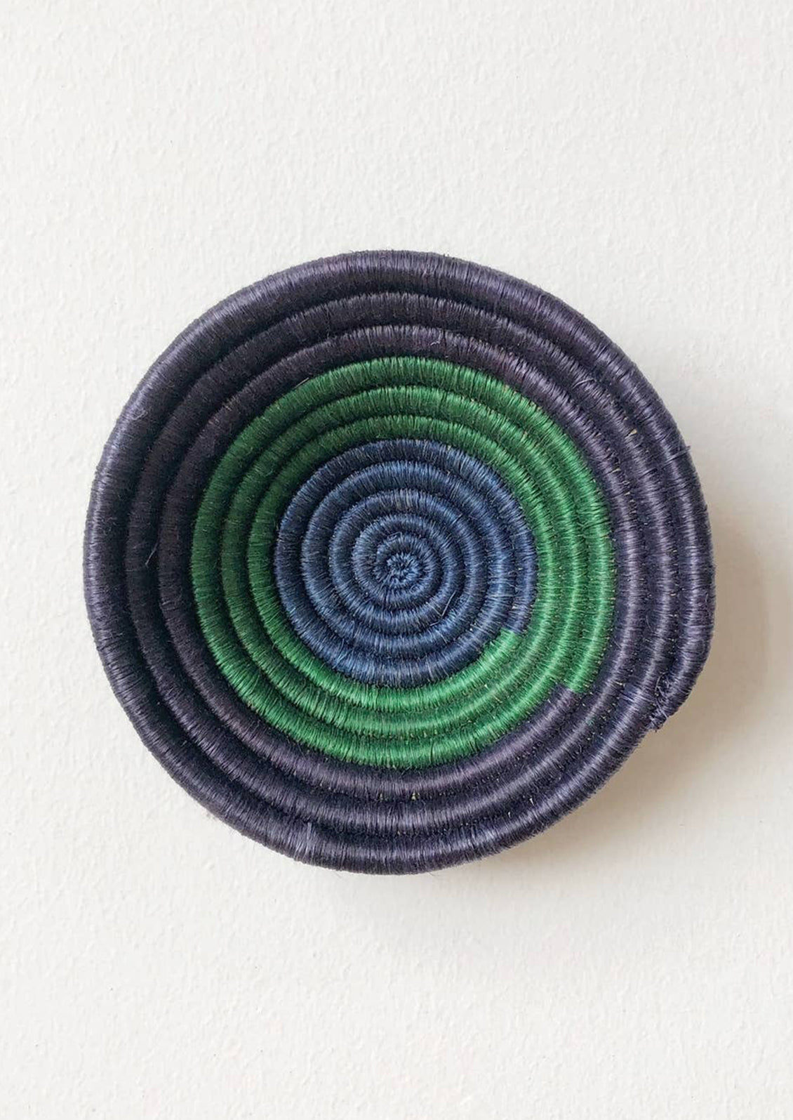 A woven sweetgrass bowl in navy and green.