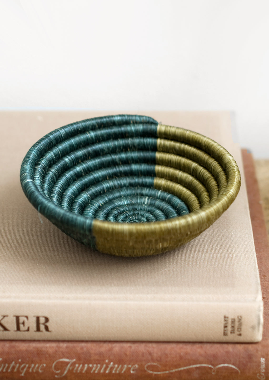 A woven sweetgrass bowl in lagoon and olive.