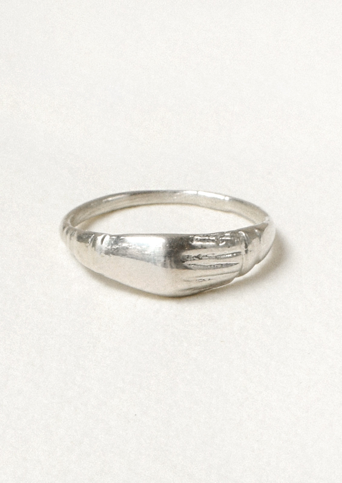 A sterling silver ring with a unique engraved design on the front.
