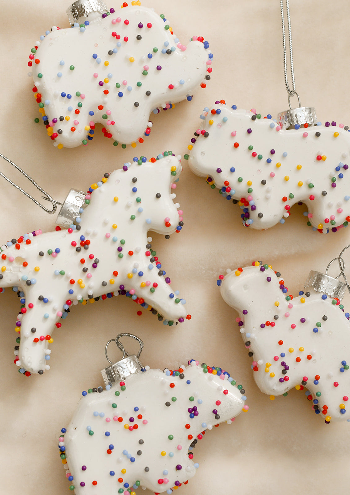 Ornaments that look like white frosted animal cookies with confetti sprinkles.
