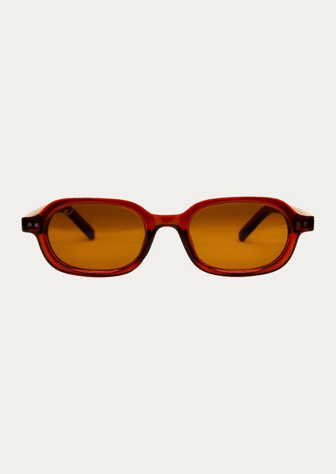 A pair of oval-rectangle sunglasses with a translucent cherry red frame and warm medium-brown tinted lenses.