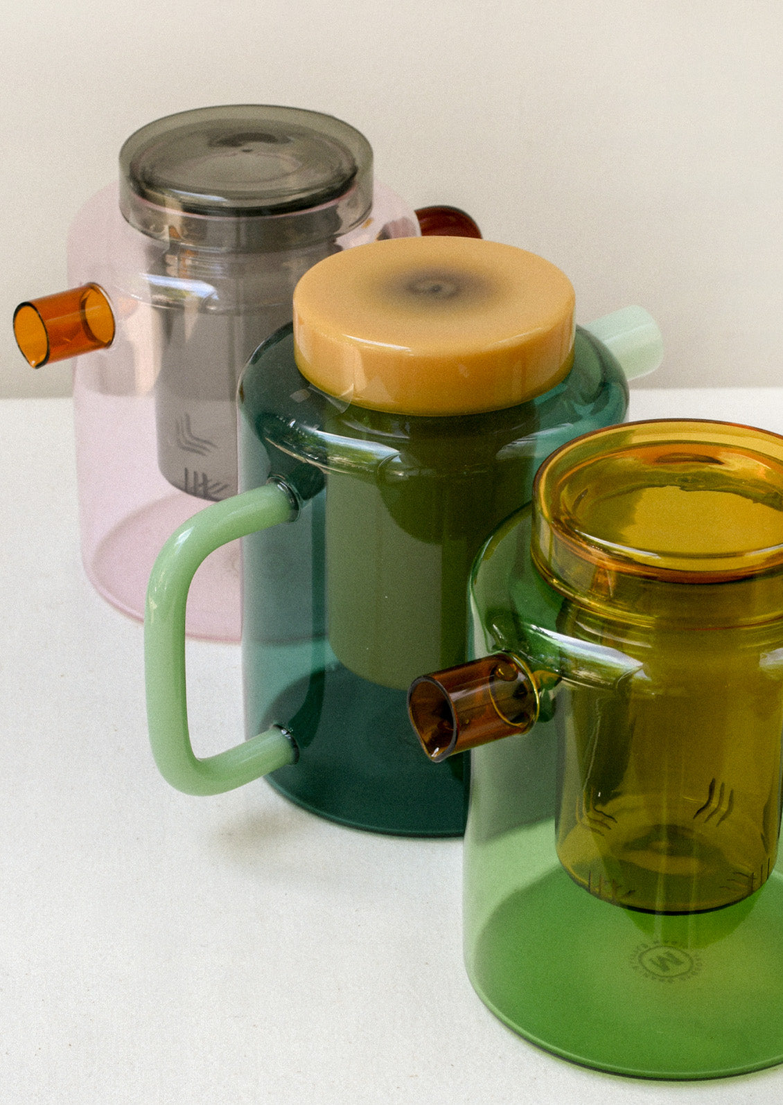 Multicolored glass teapots with removable tea steepers.