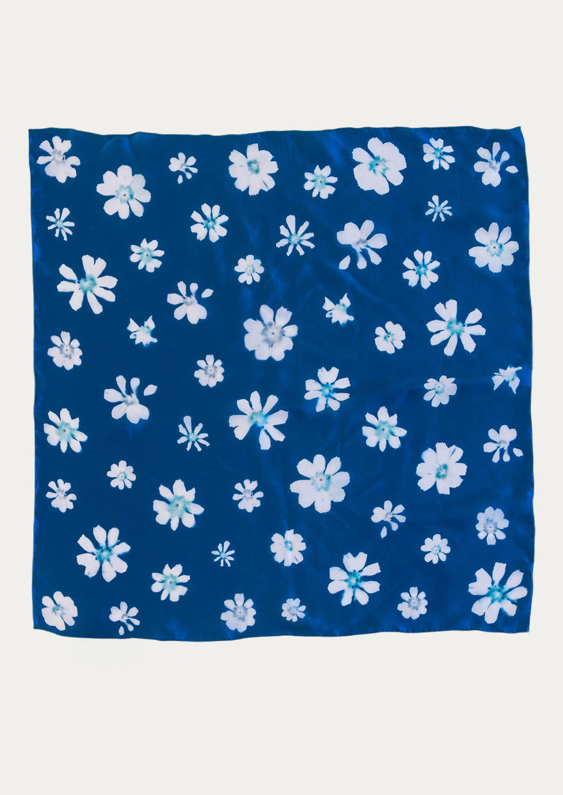 A blue square bandana with a floral cyanotype print.