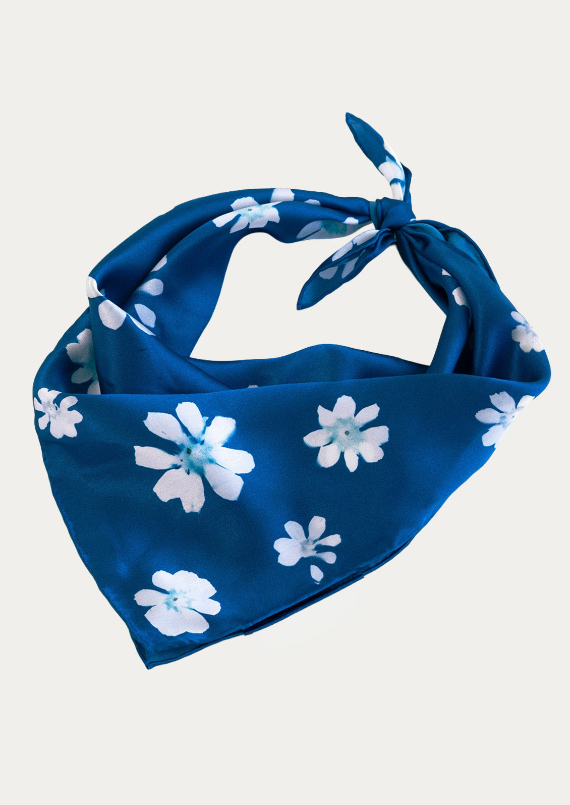 A blue square bandana with a floral cyanotype print.