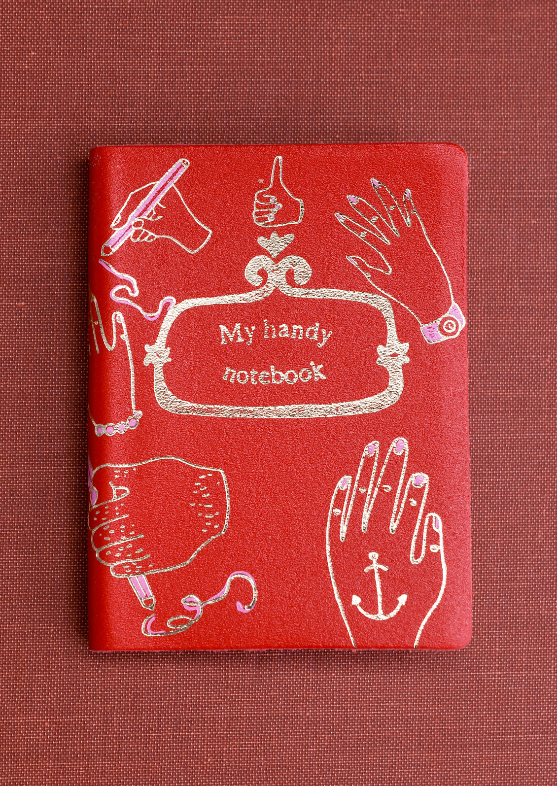 A red notebook reading "My handy notebook" on cover.
