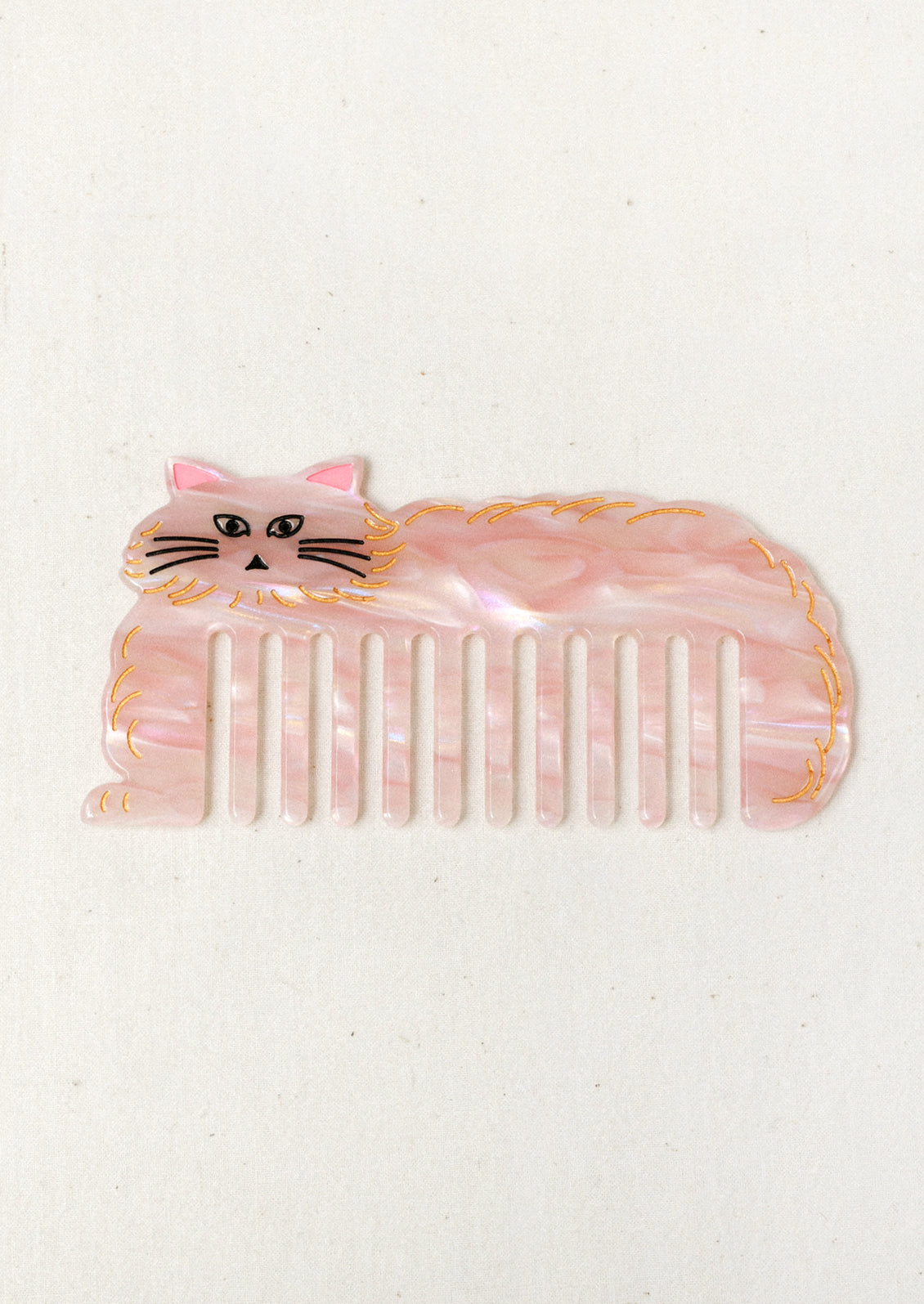 A pink hair comb in the shape of a cat.