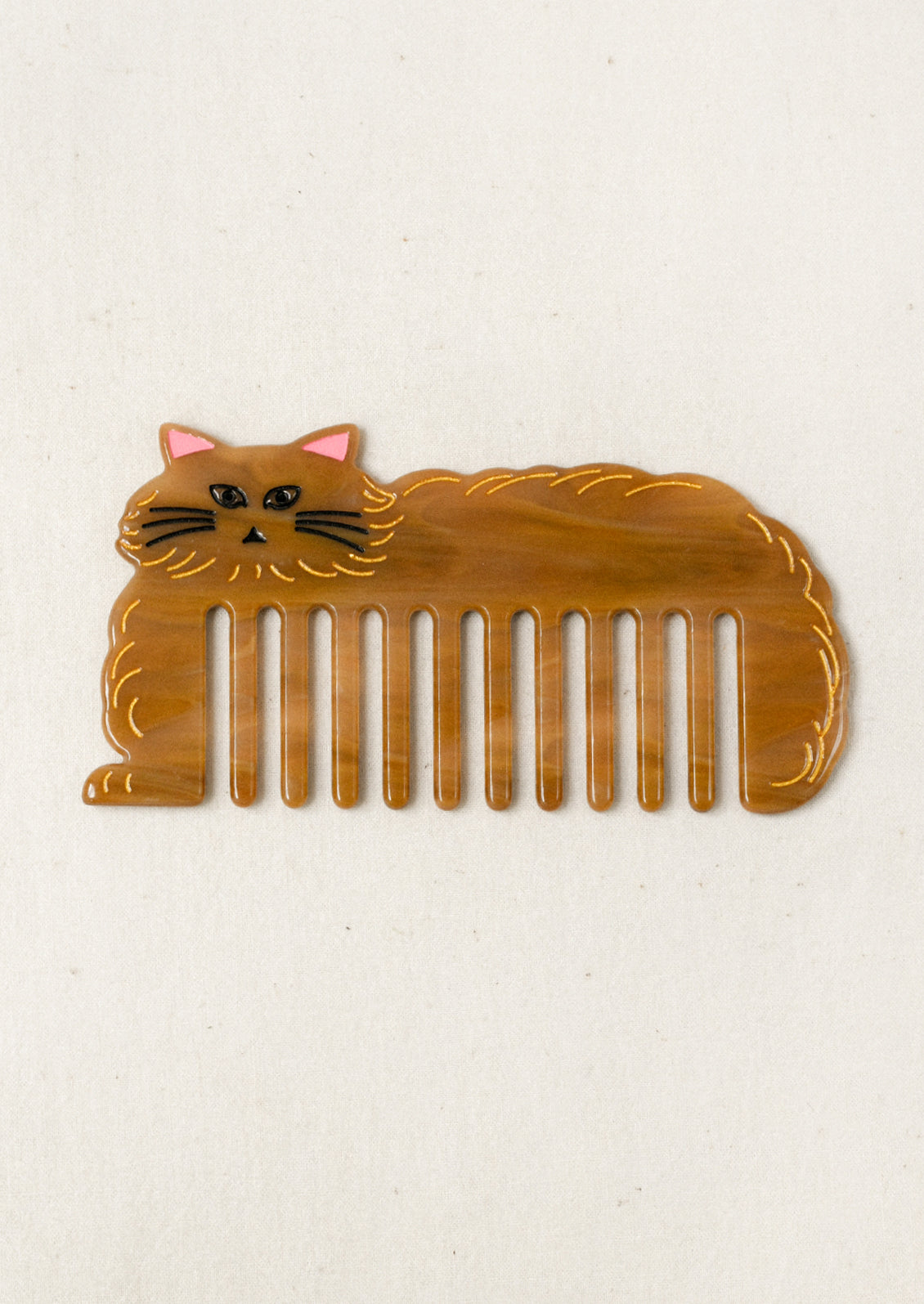 A caramel colored hair comb in the shape of a cat.