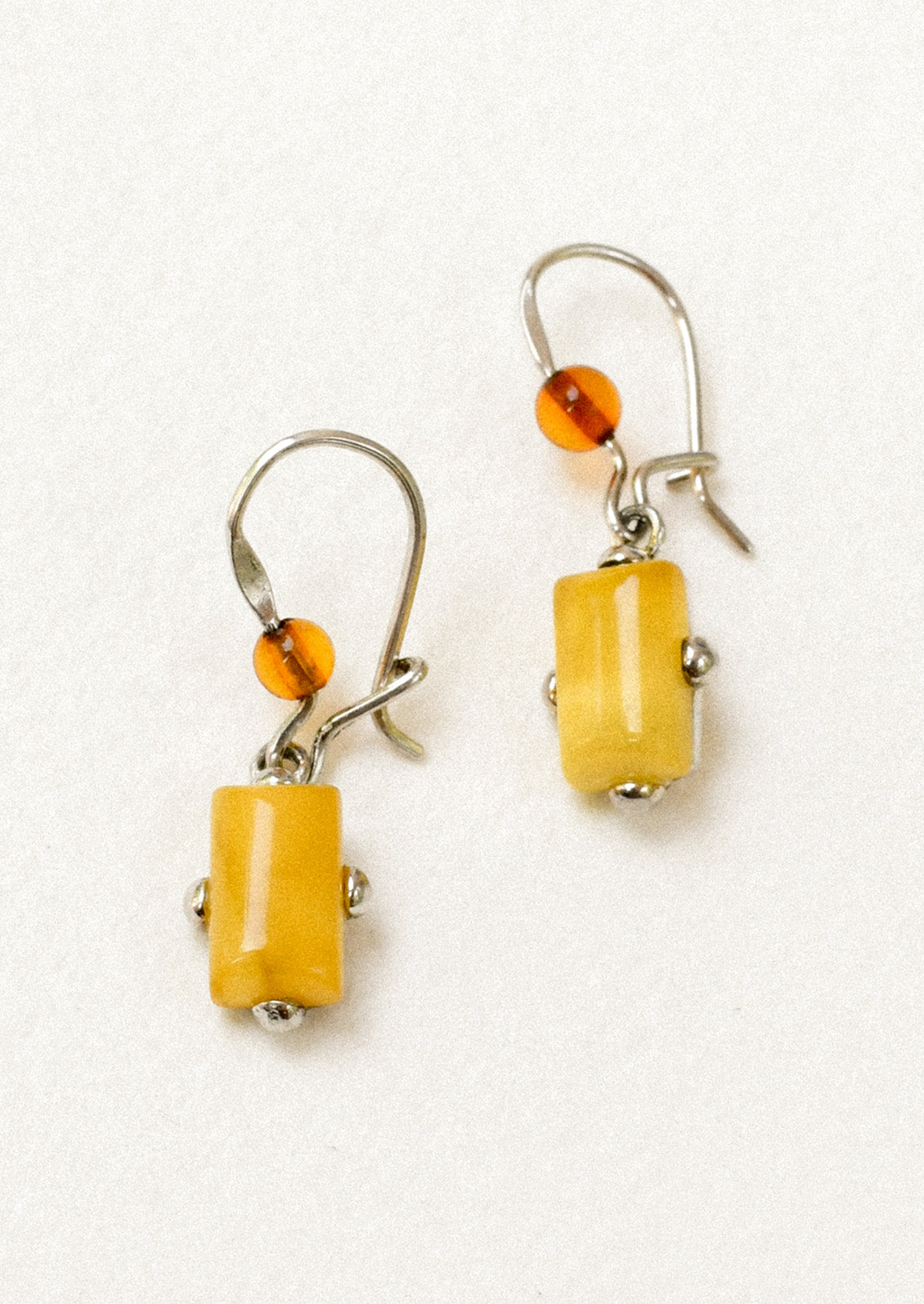 A pair of sterling silver earrings adorned with a round carnelian and a marigold stone.