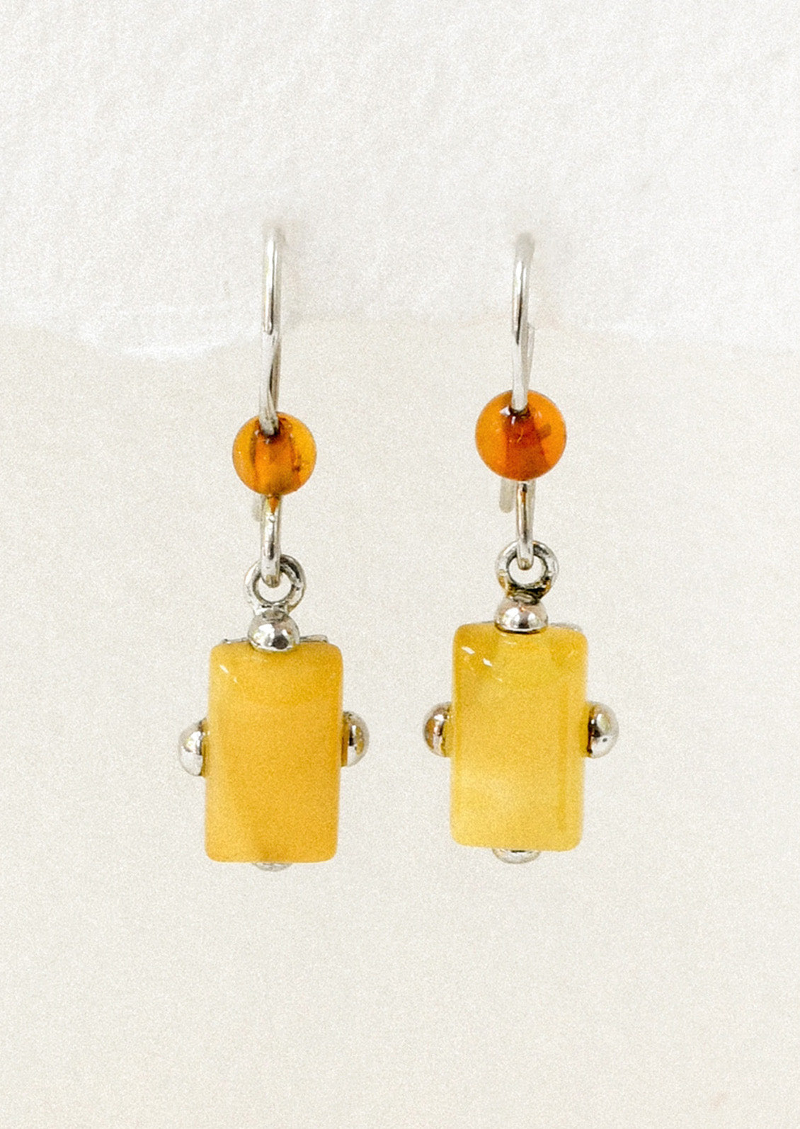 A pair of sterling silver earrings adorned with a round carnelian and a marigold stone.