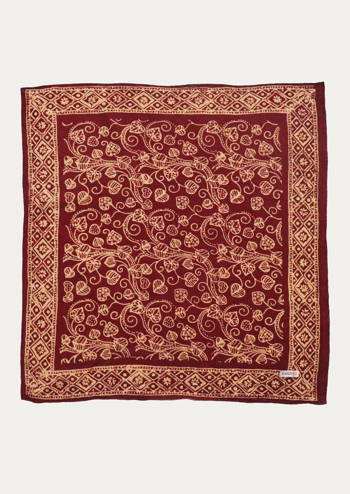 A square burgundy scarf with an intricate tan floral and vine pattern, finished with a matching geometric border.