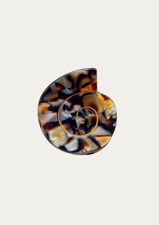 A nautilus shaped hair clip in black and tan marble.