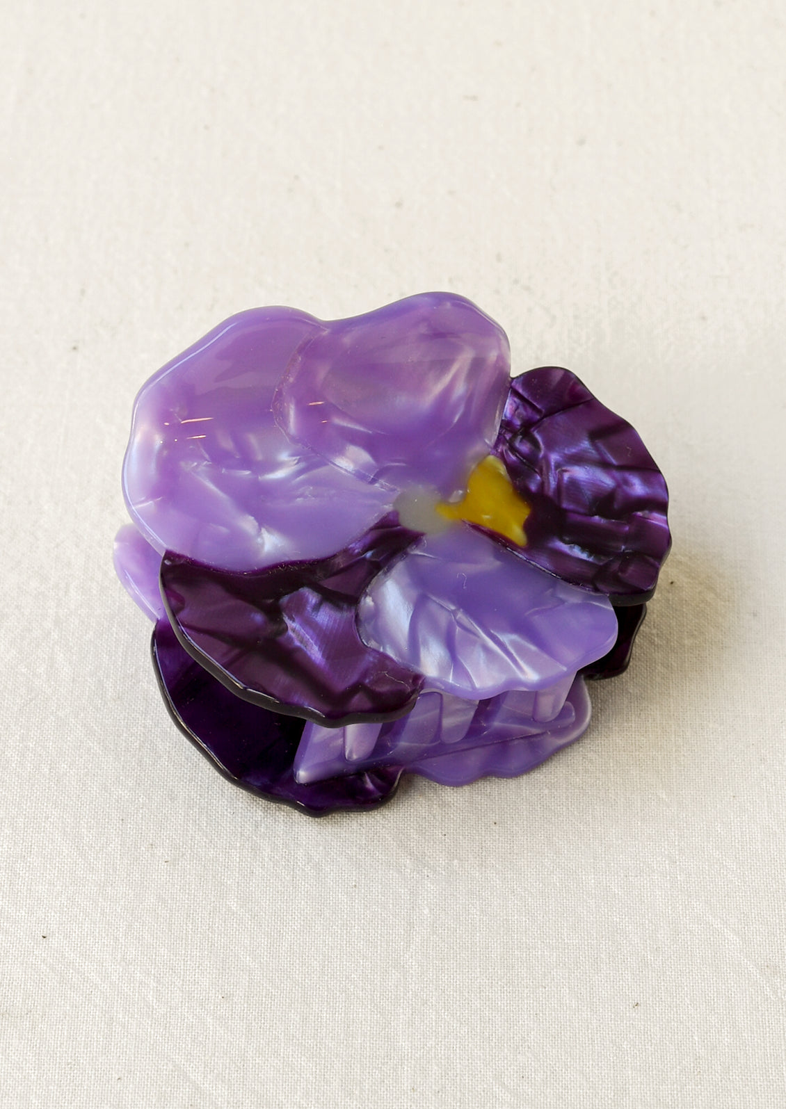 A hair claw depicting a purple pansy flower.