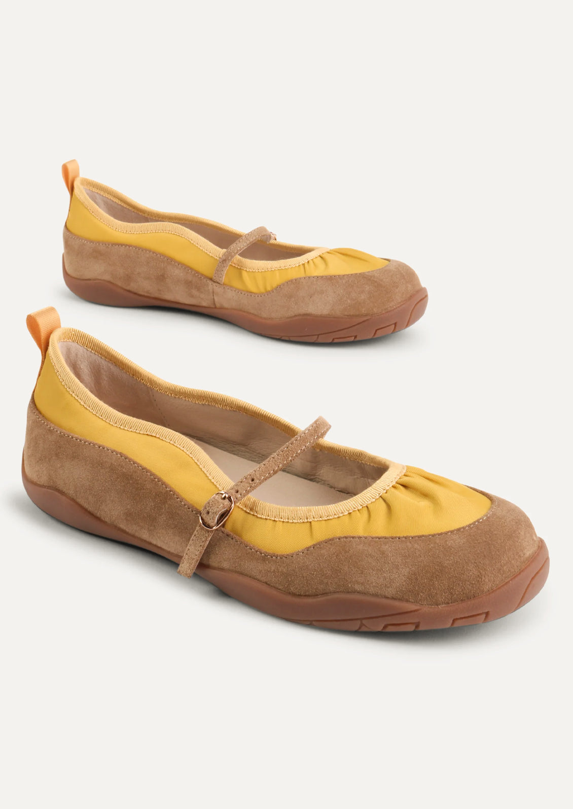 A pair of yellow and taupe shoes that are part sneaker, part ballet flat mary jane. Suede/textile upper with a rubber gum sole.