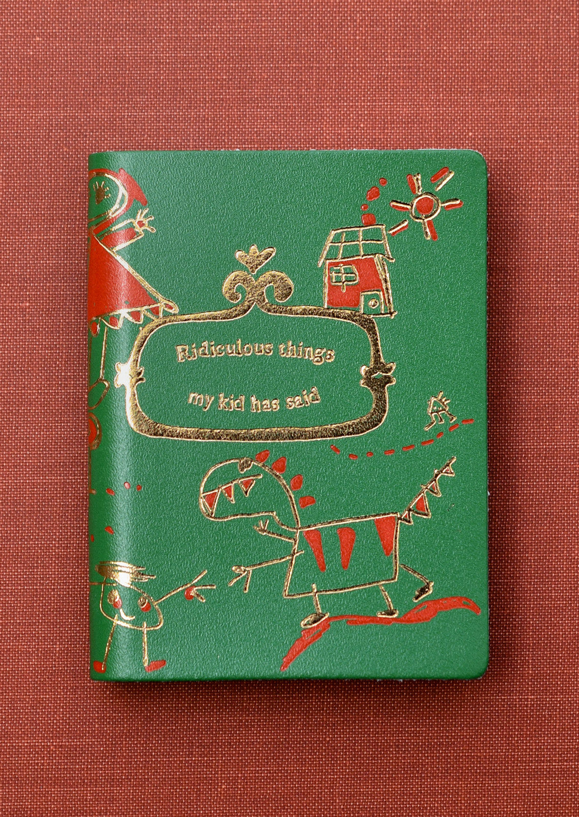 A green notebook reading "Ridiculous things my kid has said" on cover.