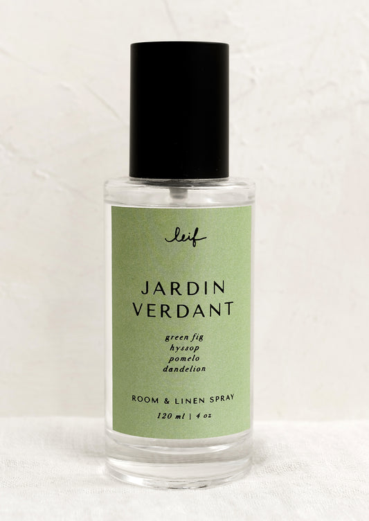 A room spray bottle with printed text on green label.