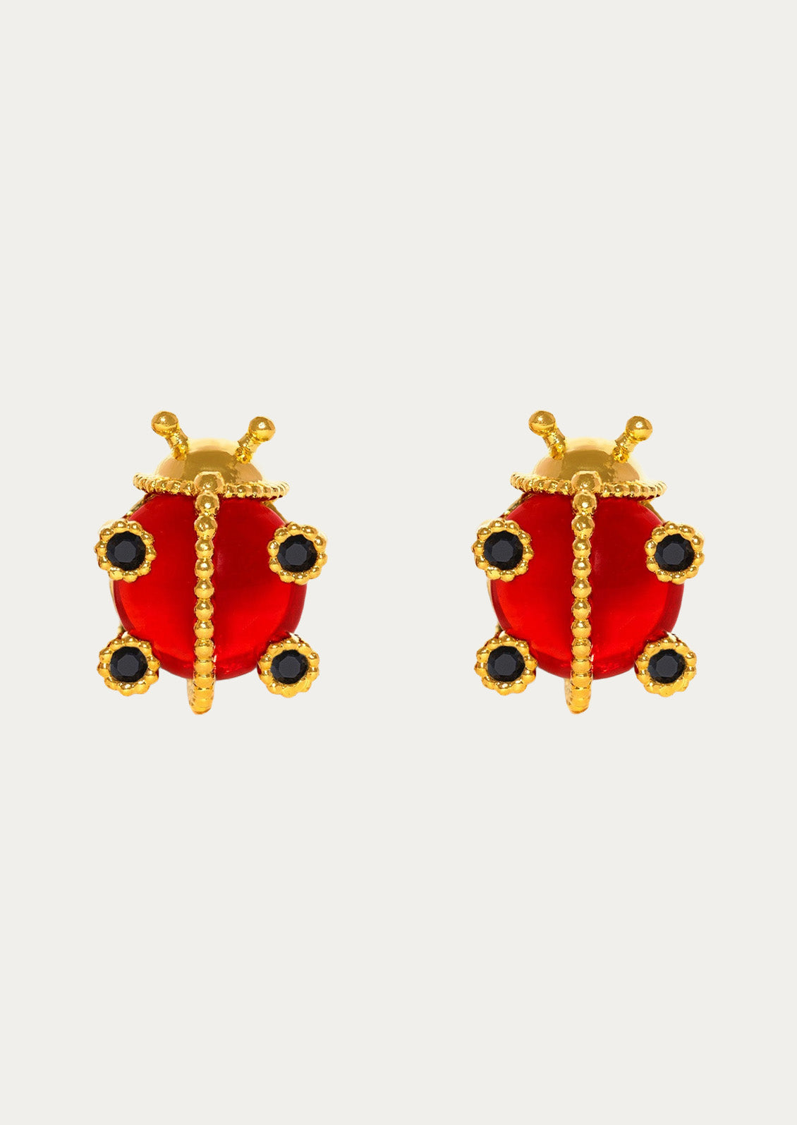 A pair of gold plated earrings in the shape of ladybugs on a white background.