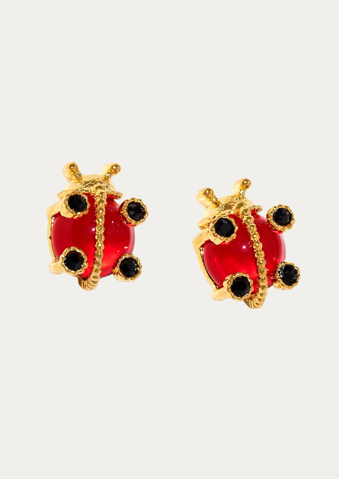 A pair of gold plated earrings in the shape of ladybugs on a white background.