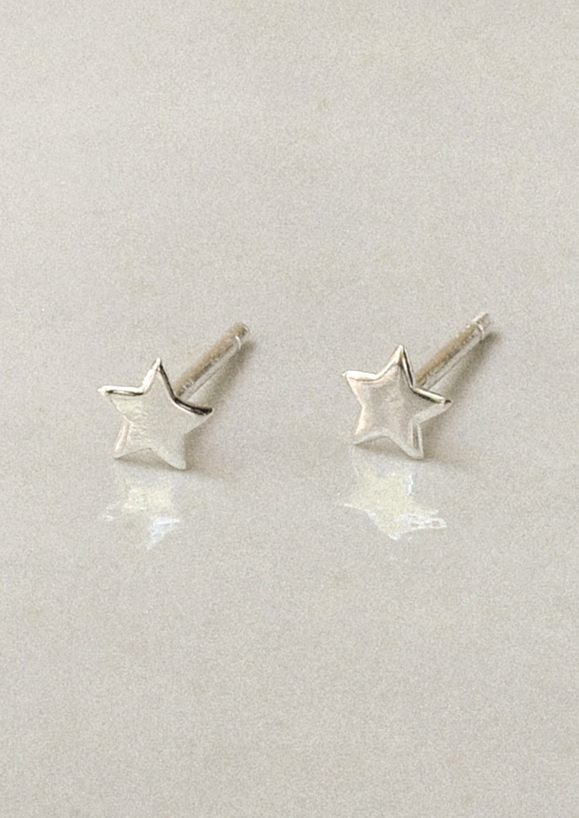 A pair of tiny sterling silver star studs.