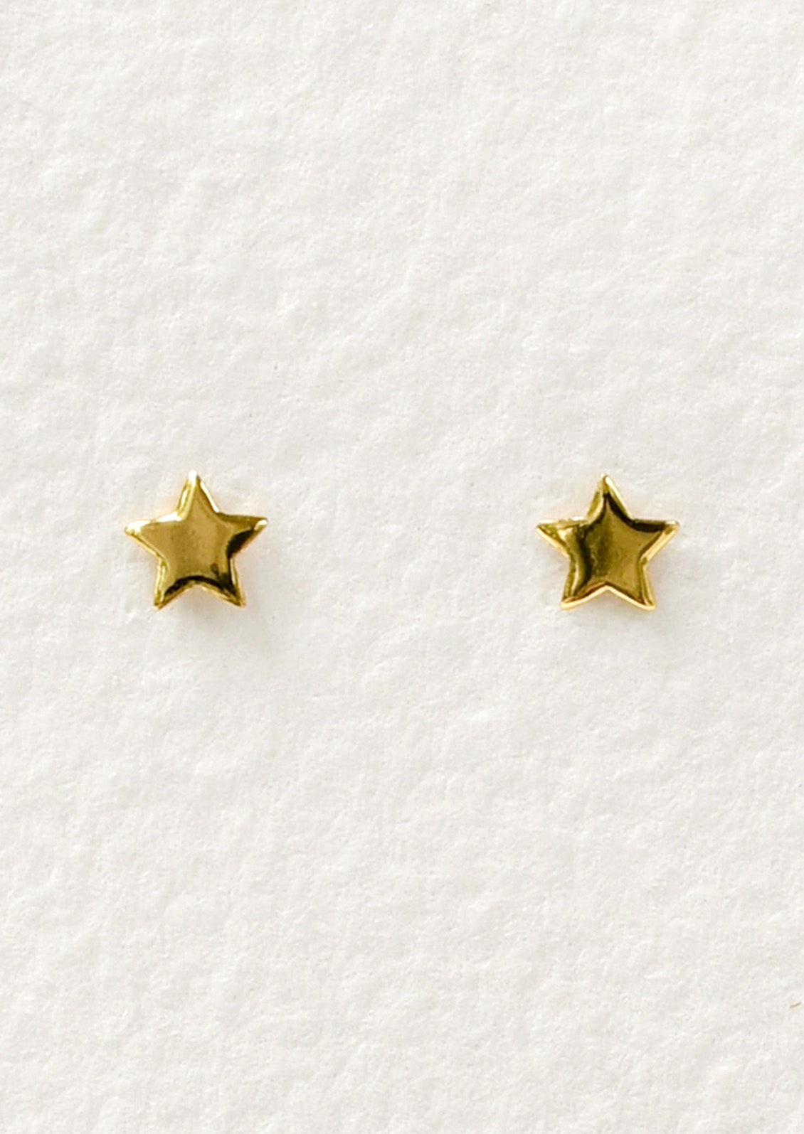 A pair of tiny gold star studs.
