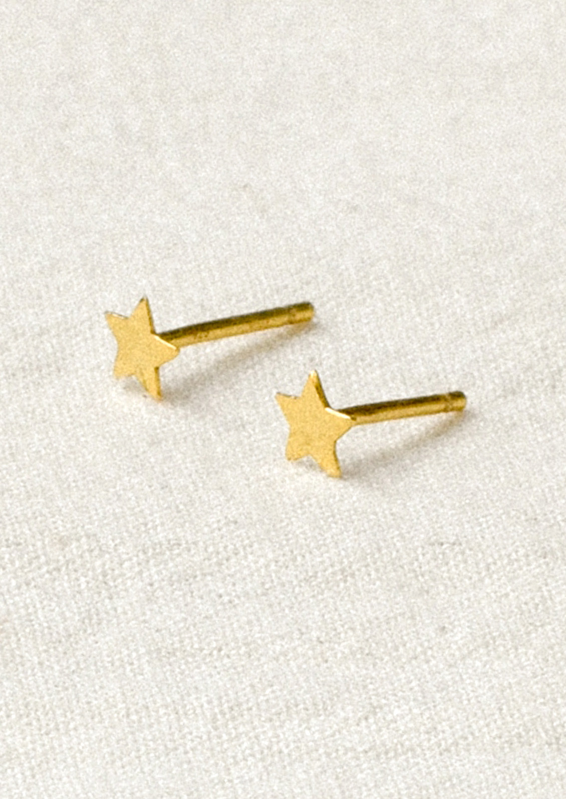 A pair of tiny gold star studs.
