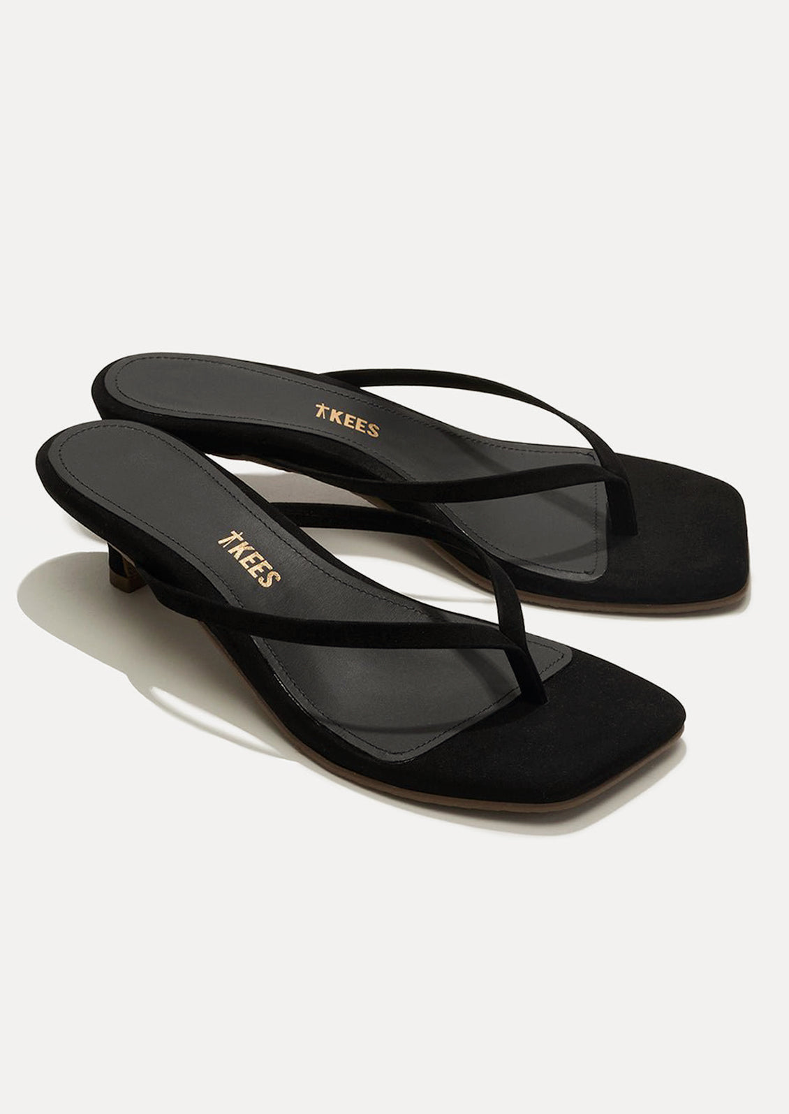 A pair of black suede kitten heel sandals with a square toe by TKEES.