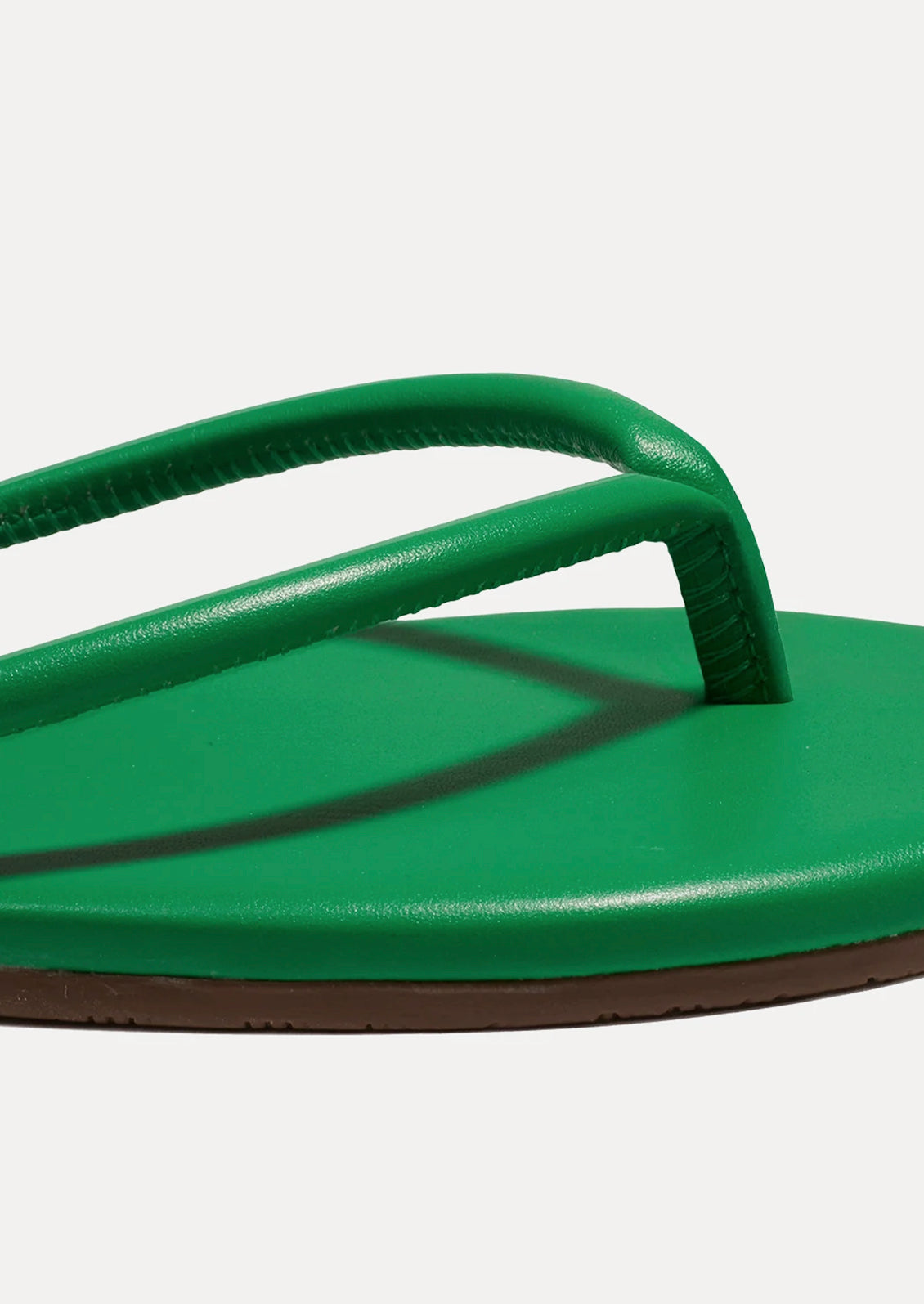 A leather TKEES sandal with a tubular strap design in kelly green.