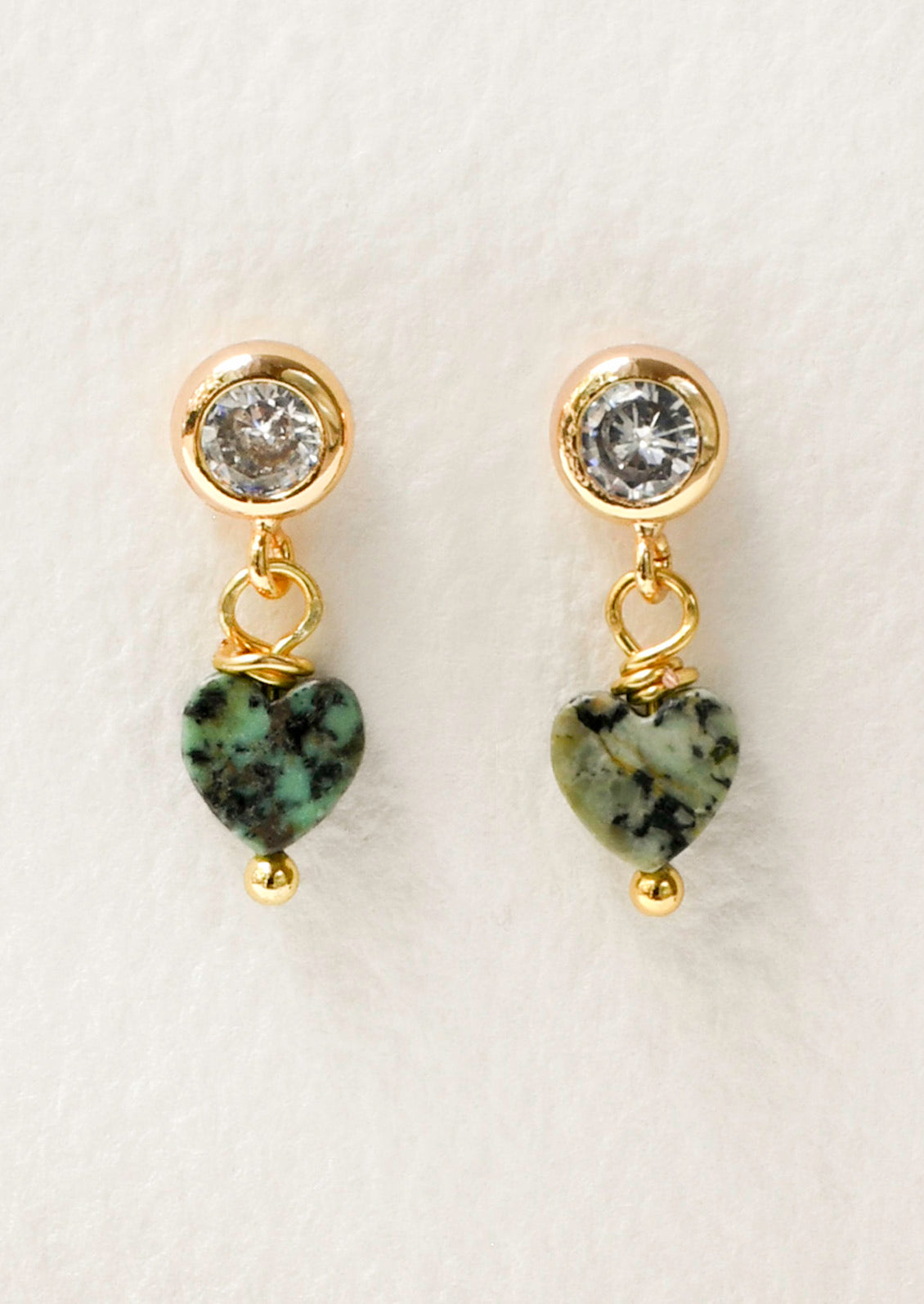 A pair of gold stud earrings with a bezeled cubic zirconia and a dangling heart shaped African turquoise gem.