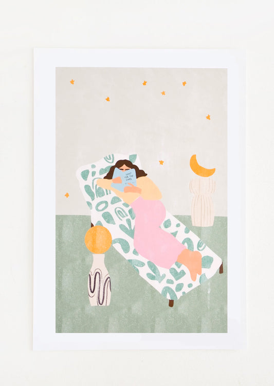 A woman in pink pants reads on a chaise lounge against a gray star filled sky.