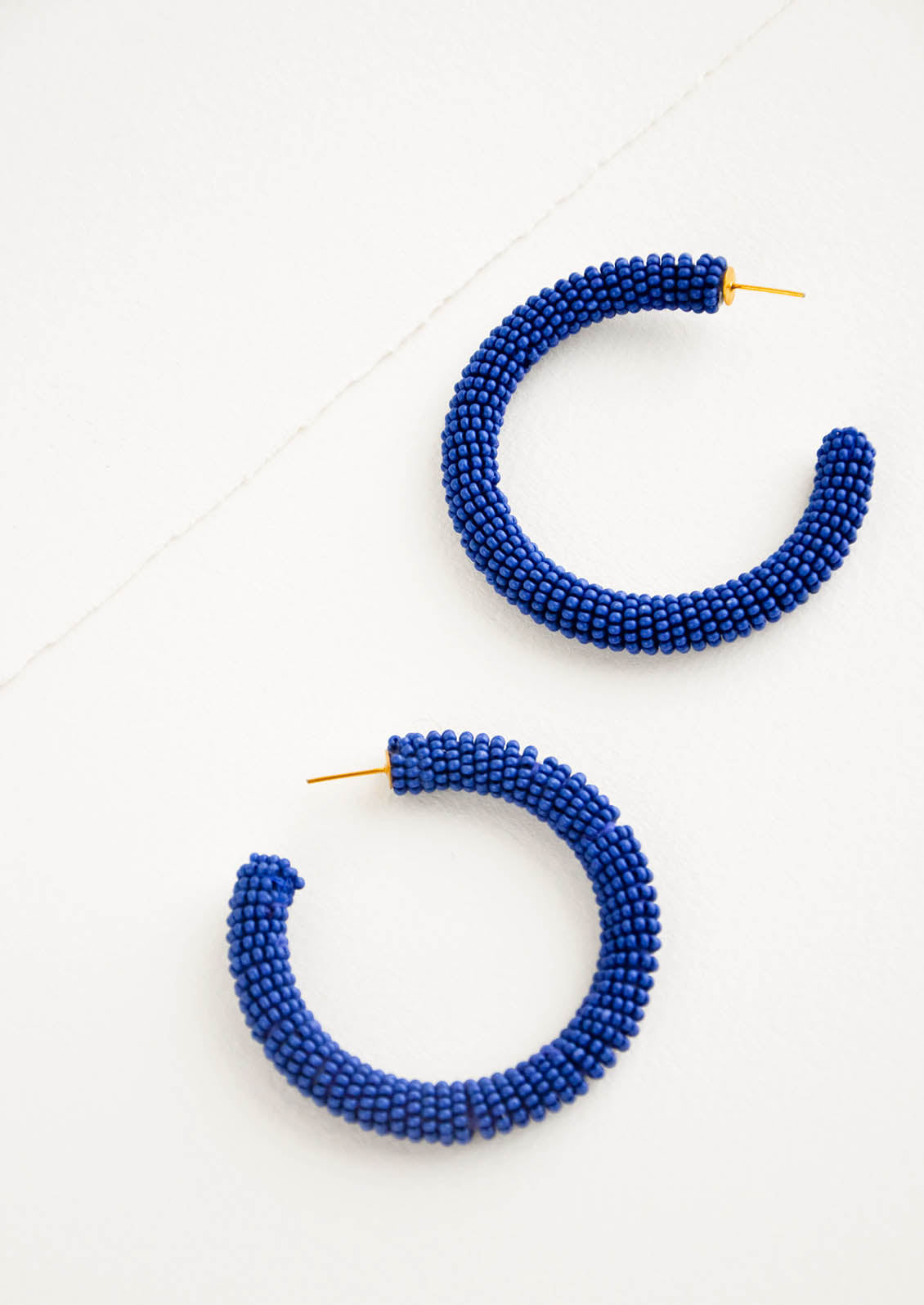 Thick hoop earrings of lapis colored glass beads.