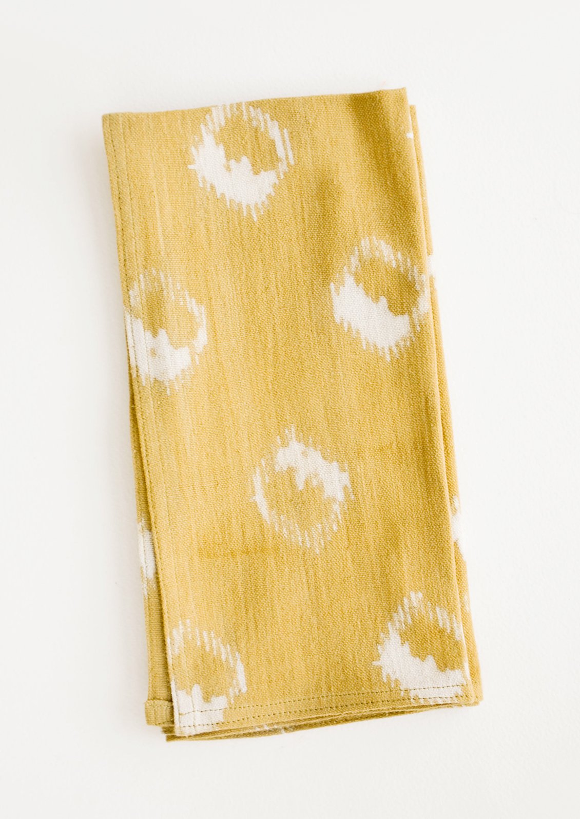 Block print cotton dinner napkin in mustard yellow with ikat print
