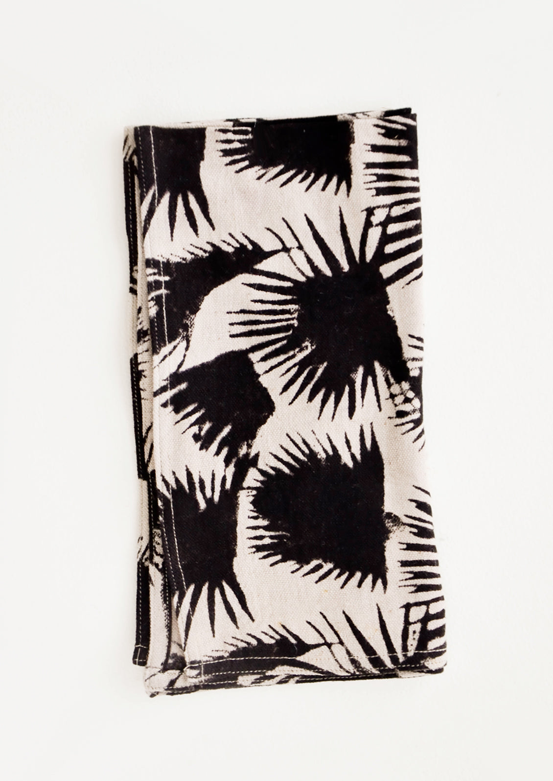 Block print cotton dinner napkin in beige with black palm leaf print