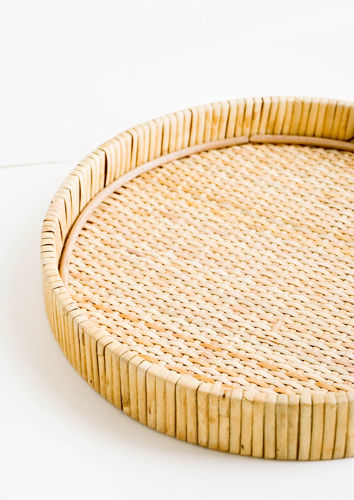 Round serving tray with raised rim, made from woven rattan