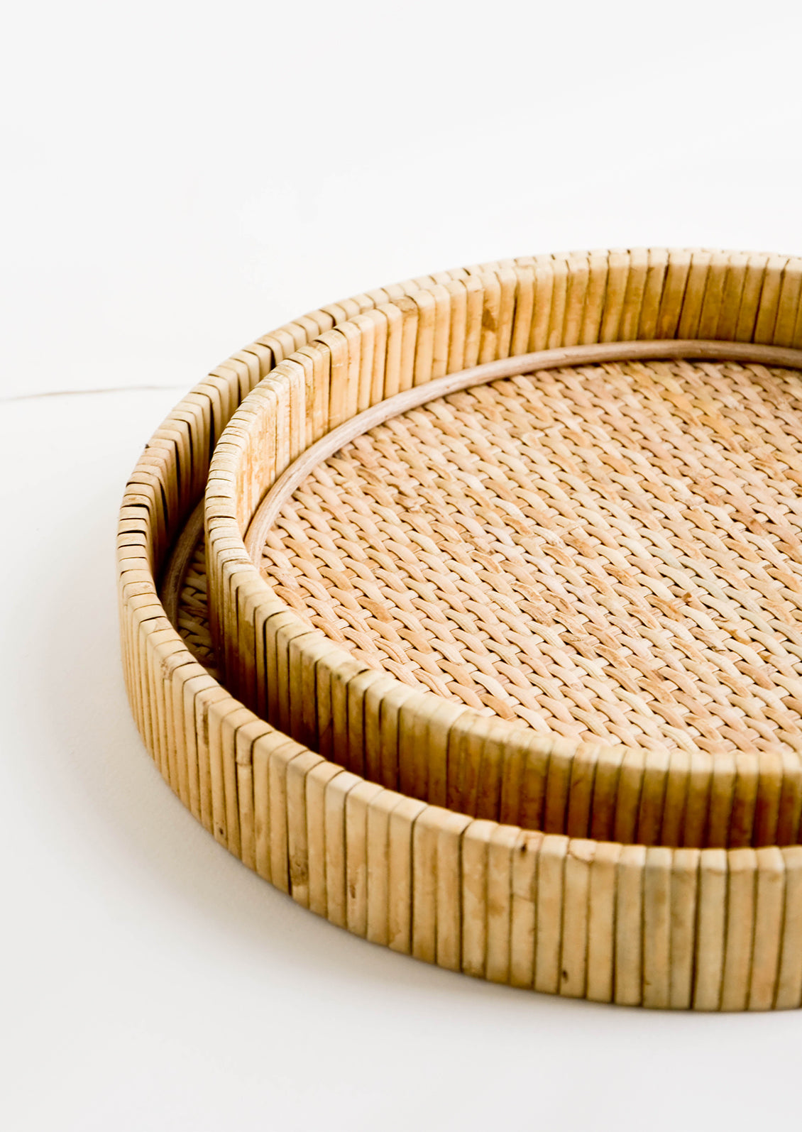 Nesting circular serving trays made from woven rattan