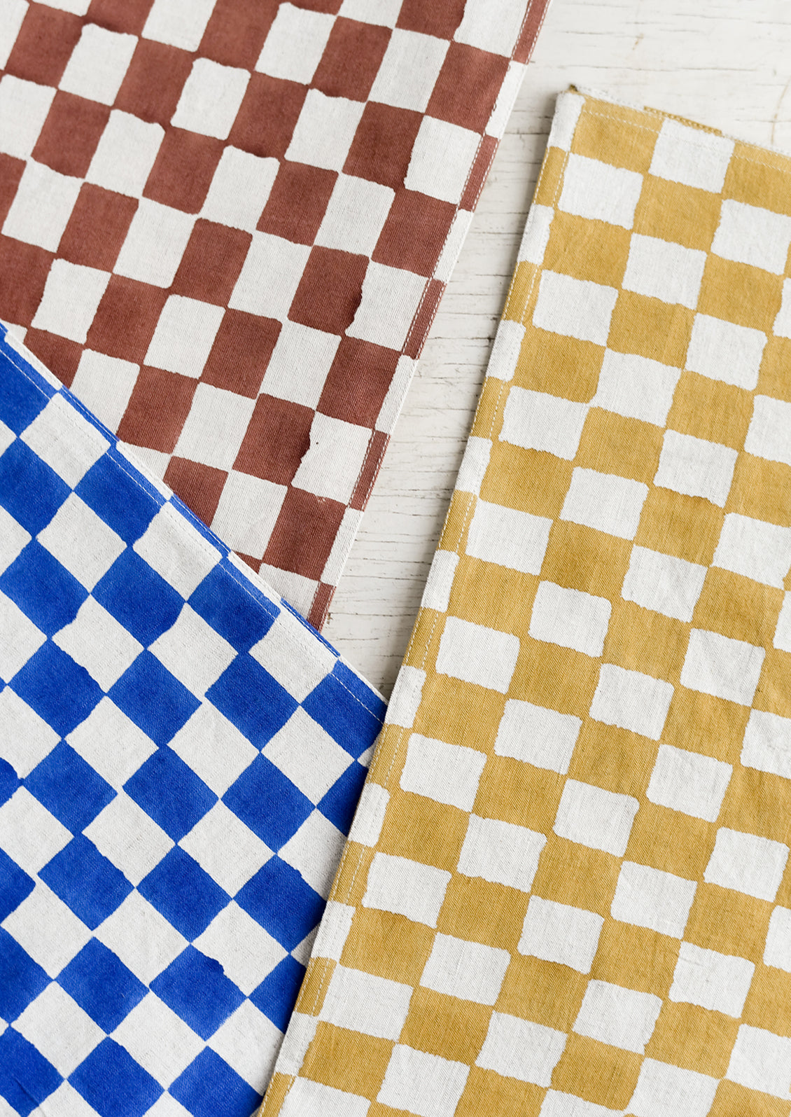 Checker patterned table runners in three colors.
