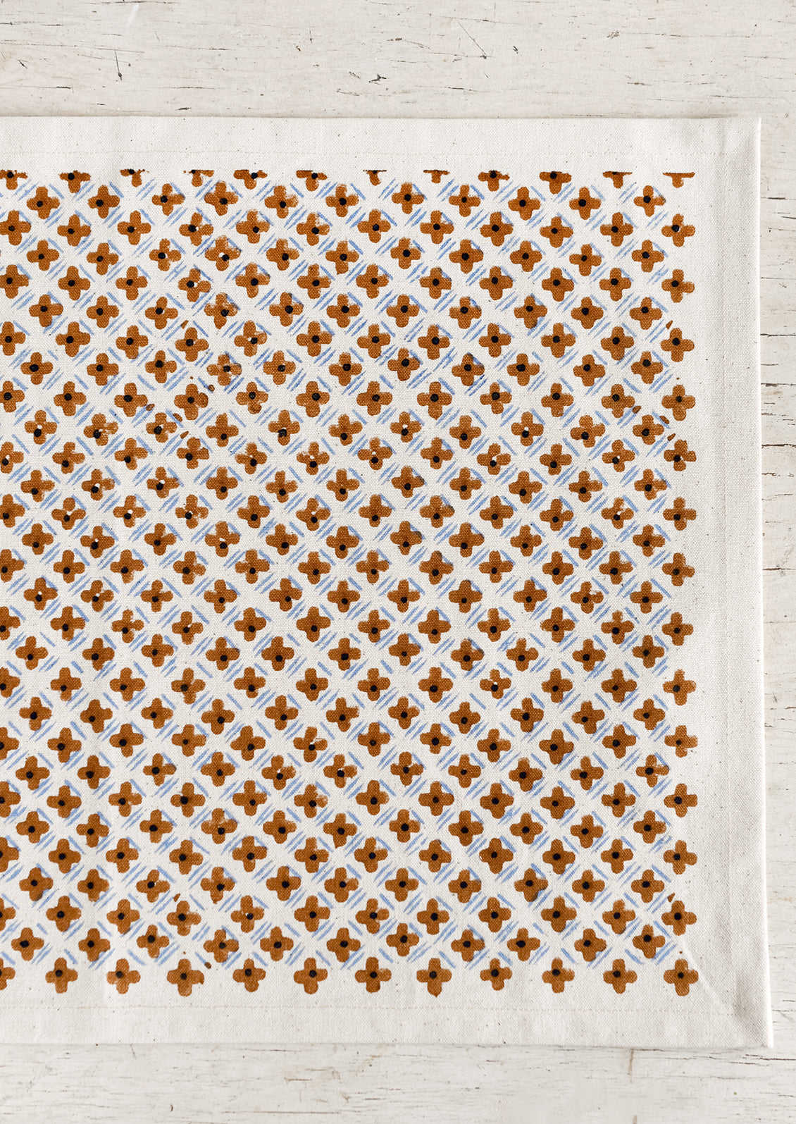 A placemat with tiny floral diamond formation pattern.