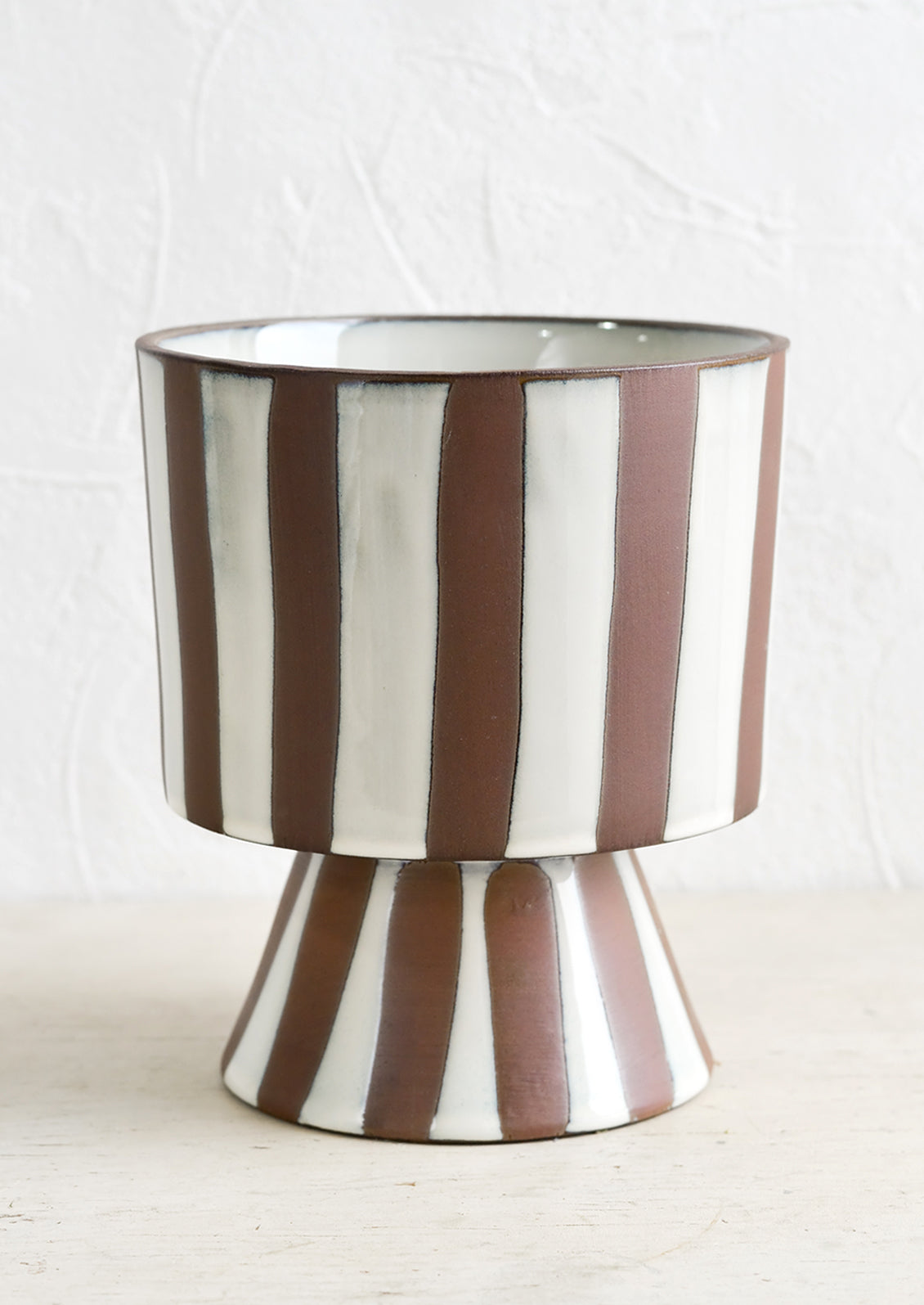 A brown and white striped footed planter.