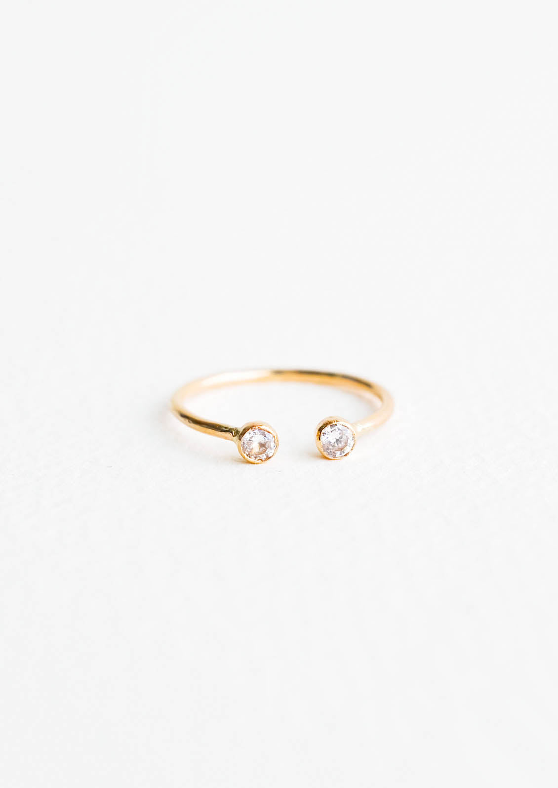 Yellow gold adjustable ring with opening at front and yellow stone on each side of the opening.
