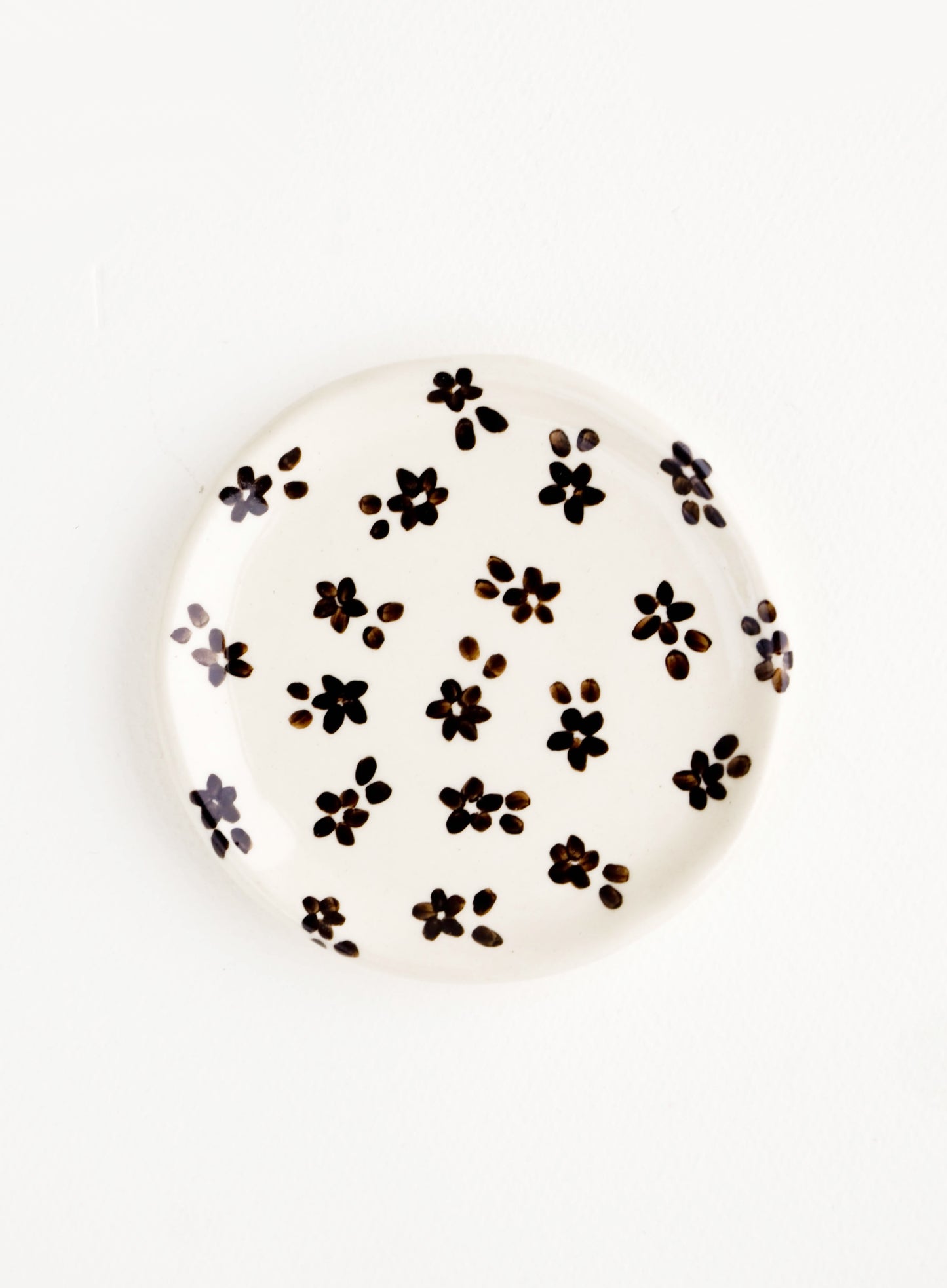 Small, round ceramic dish in white with black floral print