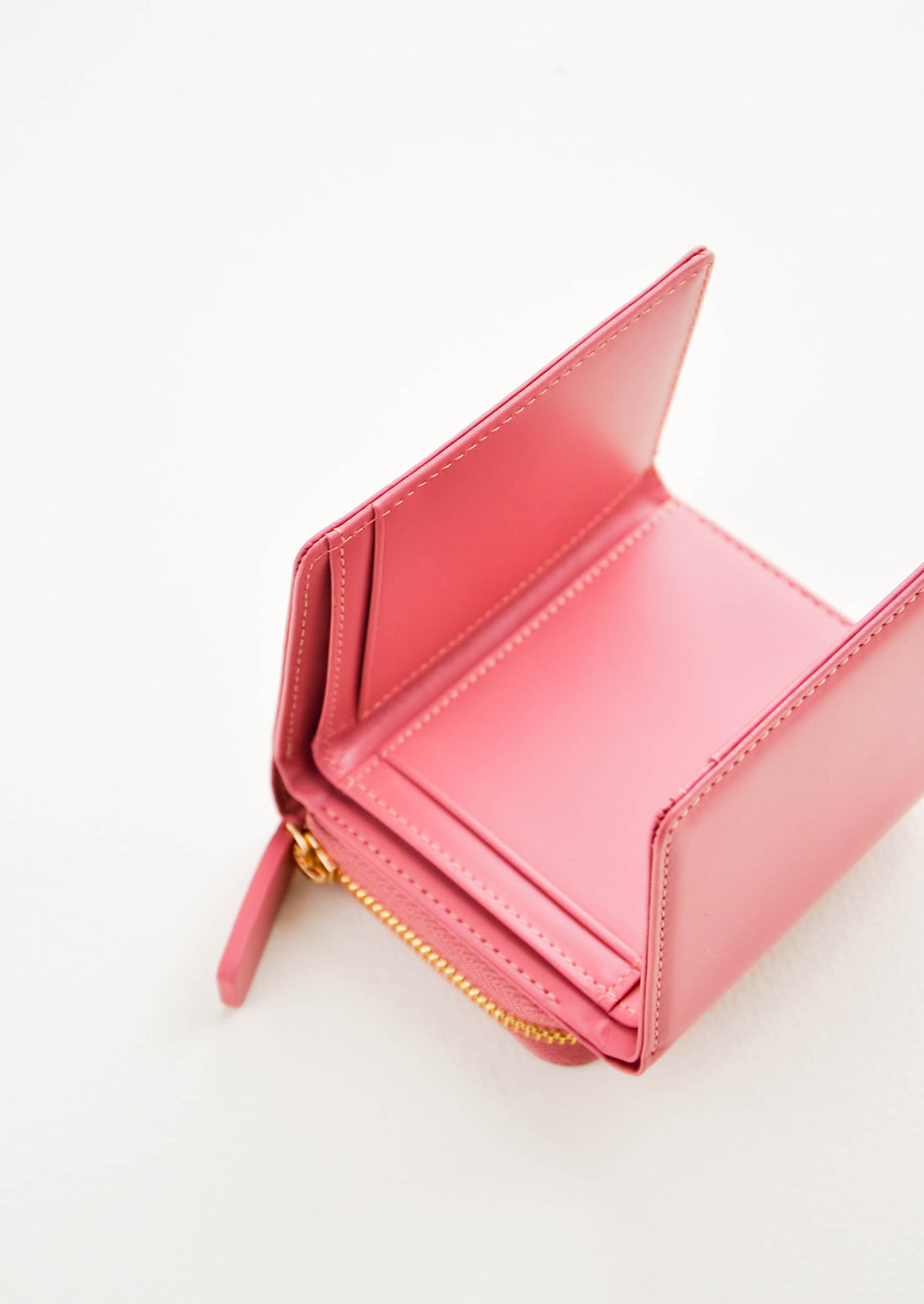Inside of a red leather wallet that is unfolded to show multiple pockets for credit cards. 