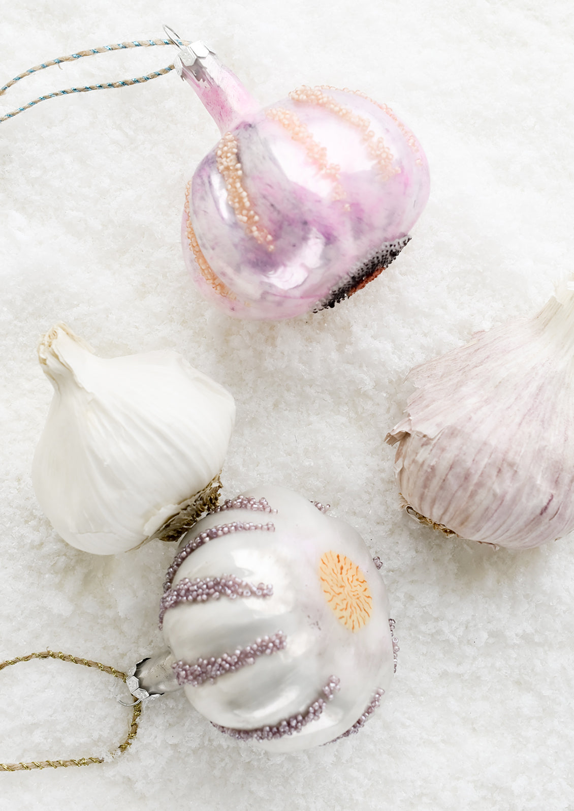 Garlic ornaments next to real garlic.