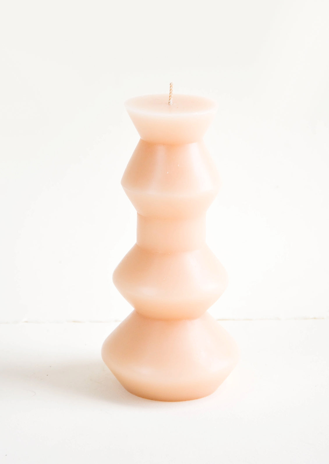 Shapely, peach colored pillar candle in chunky geometric form